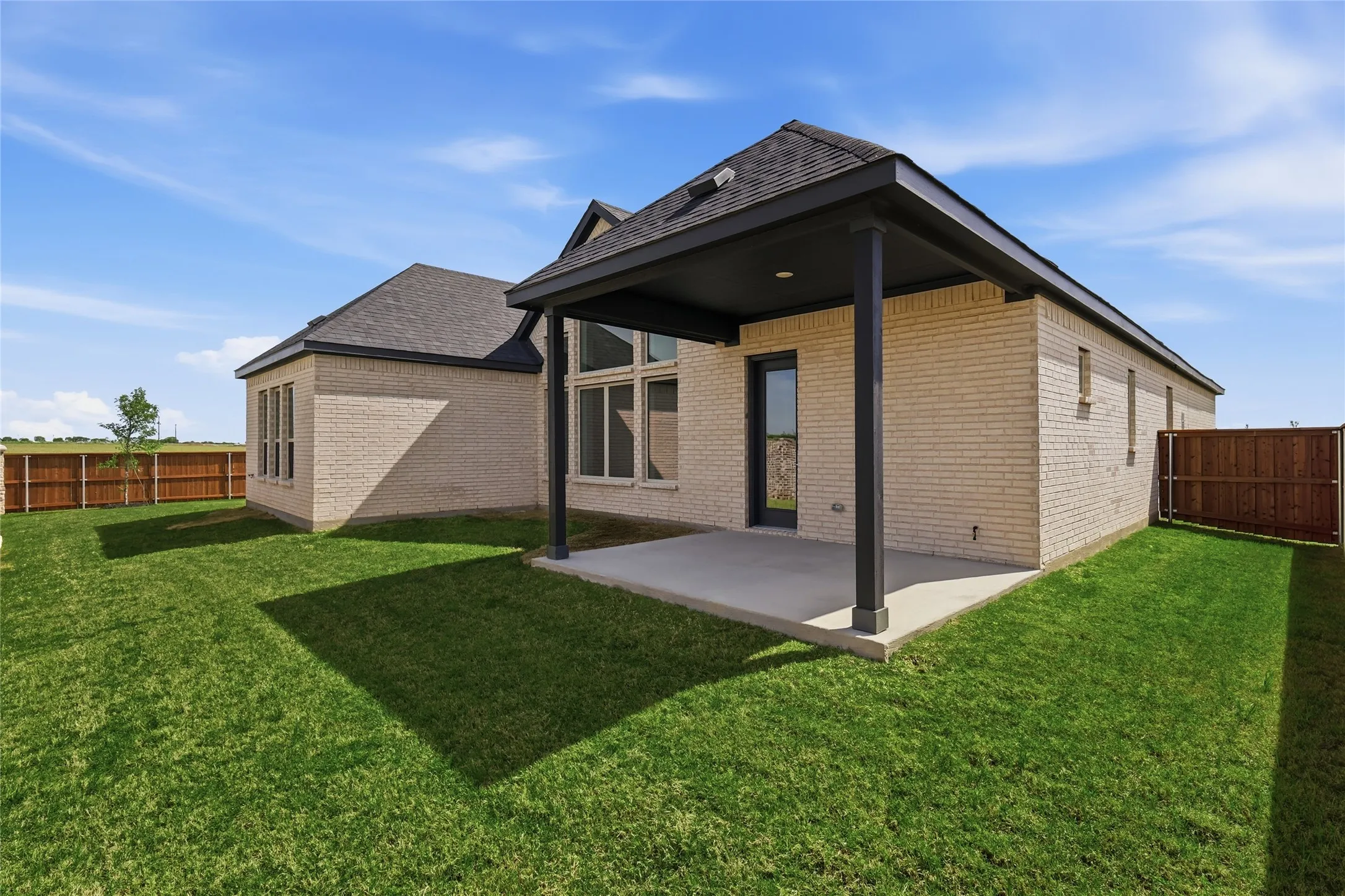 Rear view of property featuring a fenced backyard, a patio area, and brick siding