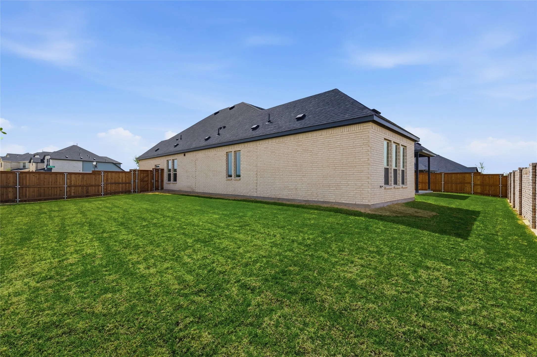 Rear view of property featuring a fenced backyard and brick siding