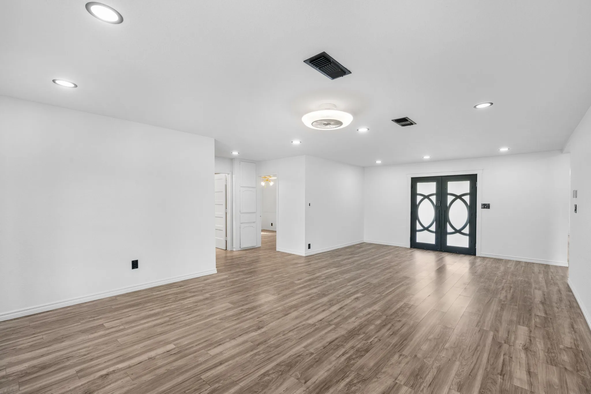 Unfurnished living room with dark wood-type flooring and recessed lighting