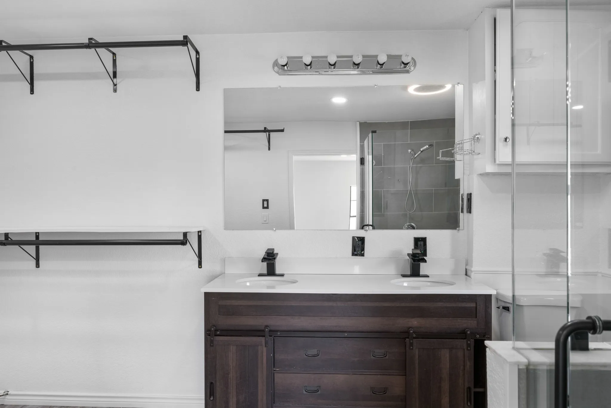 Full bath featuring a shower stall and double vanity