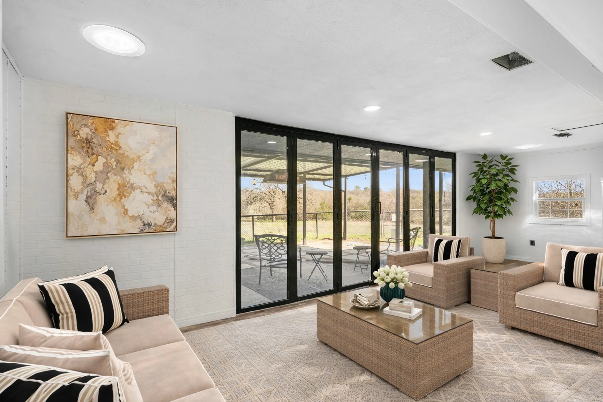 Living area with floor to ceiling windows and recessed lighting Virtually staged to show use of space
