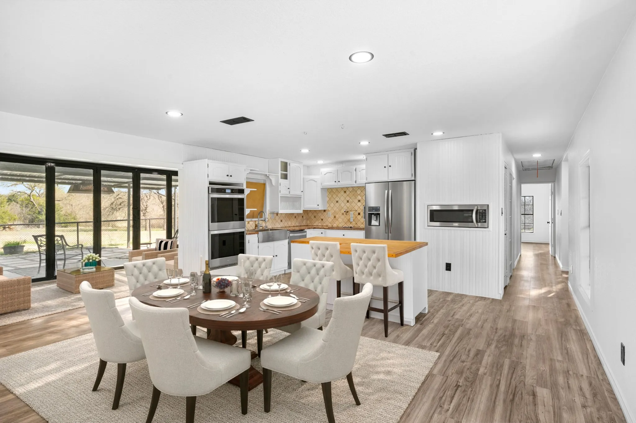 Dining room with light wood-style flooring and recessed lighting Virtually staged to show appropriate use of space