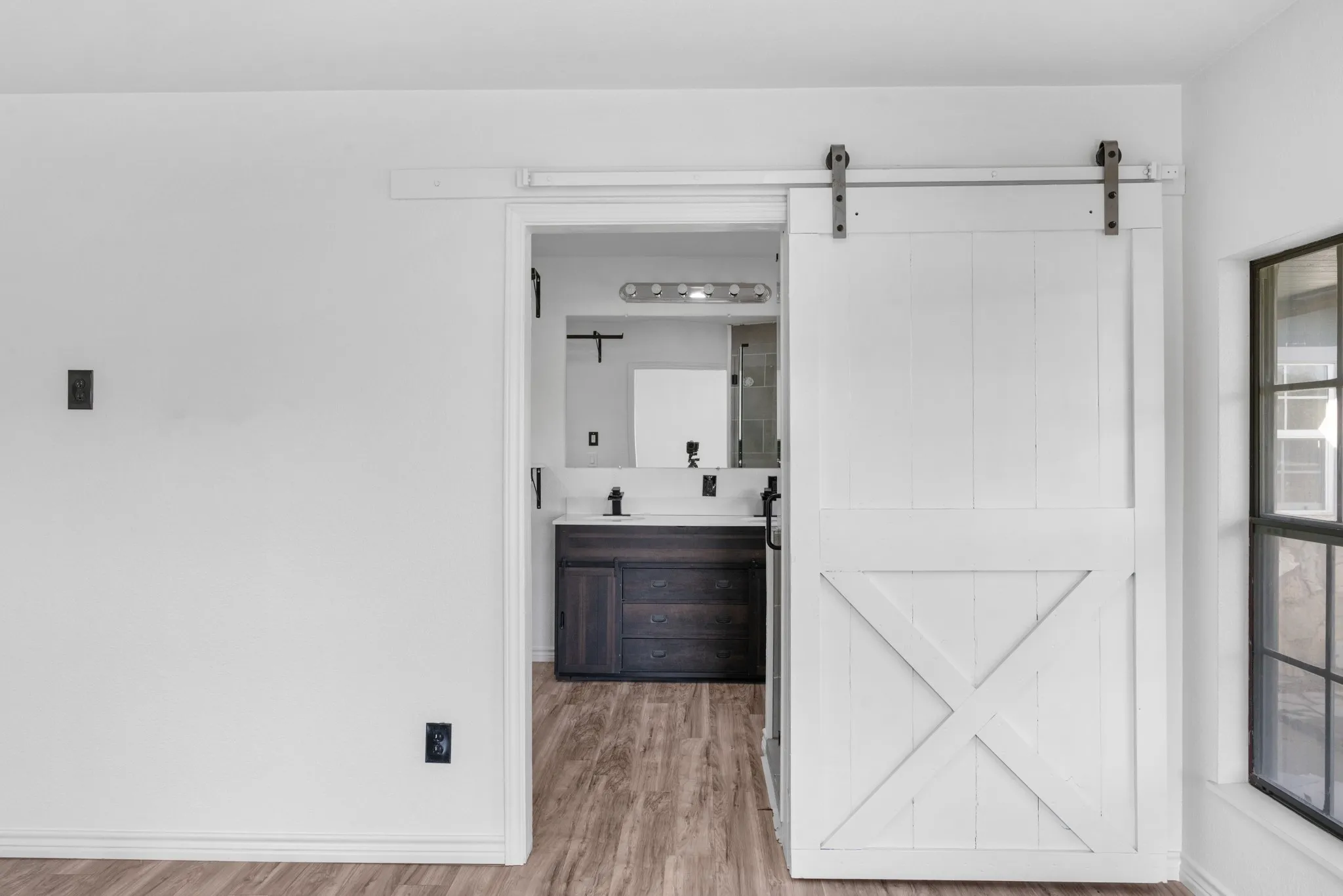 Full bath featuring double vanity and light wood finished floors
