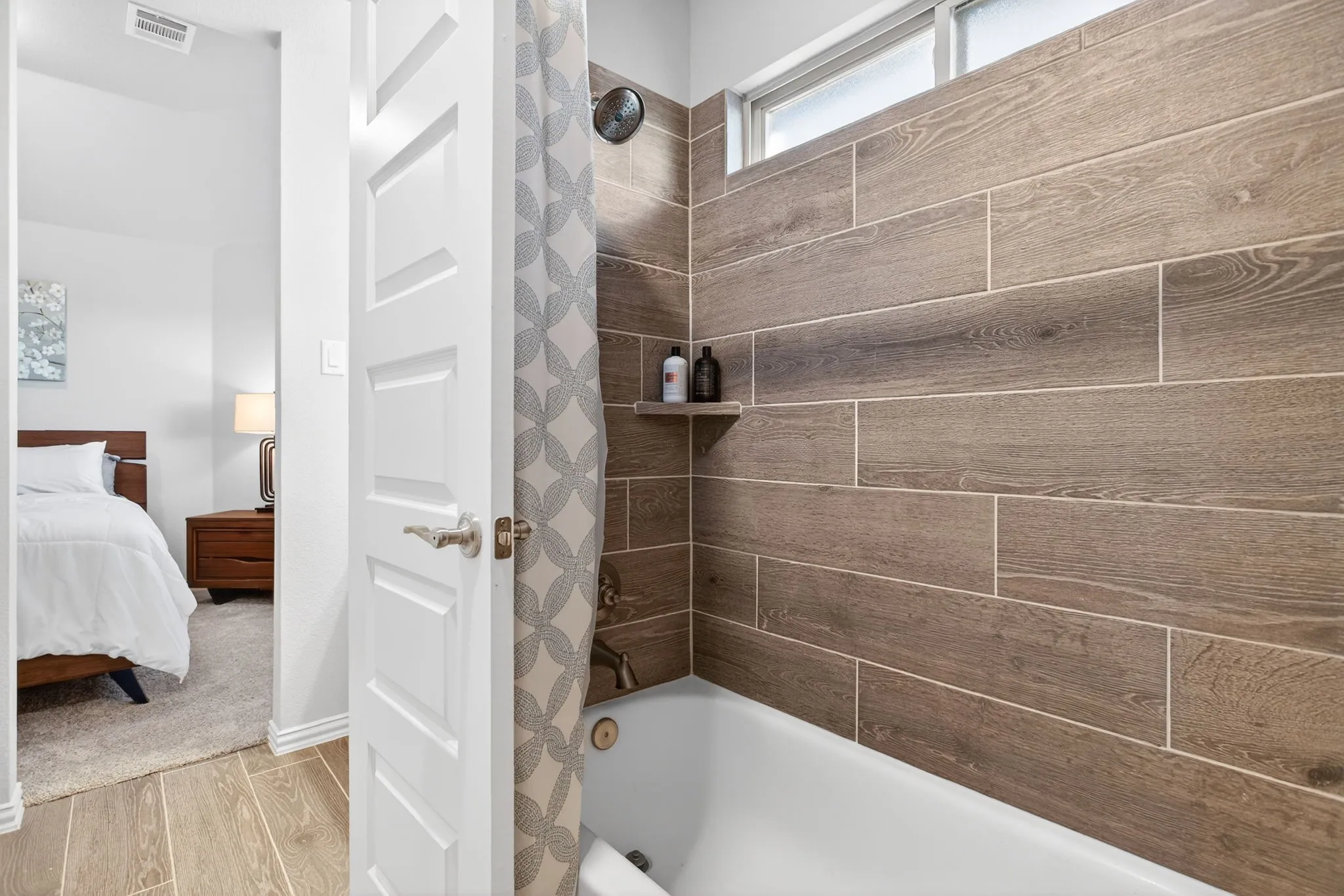Beautifully tiled tub-shower combo. Transom window for some extra light.