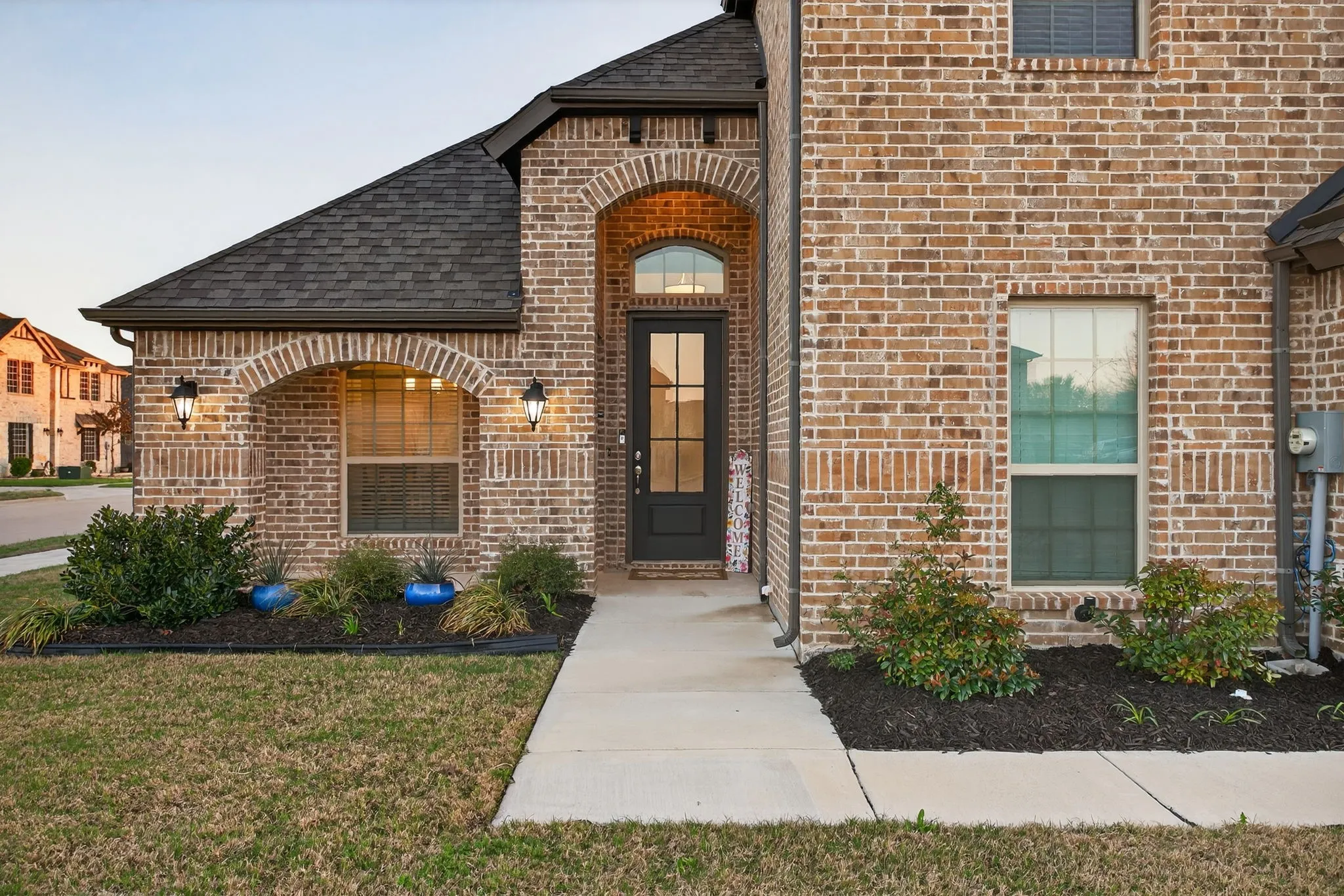 Charming front porch with carriage lighting...the front of the home says Welcome!