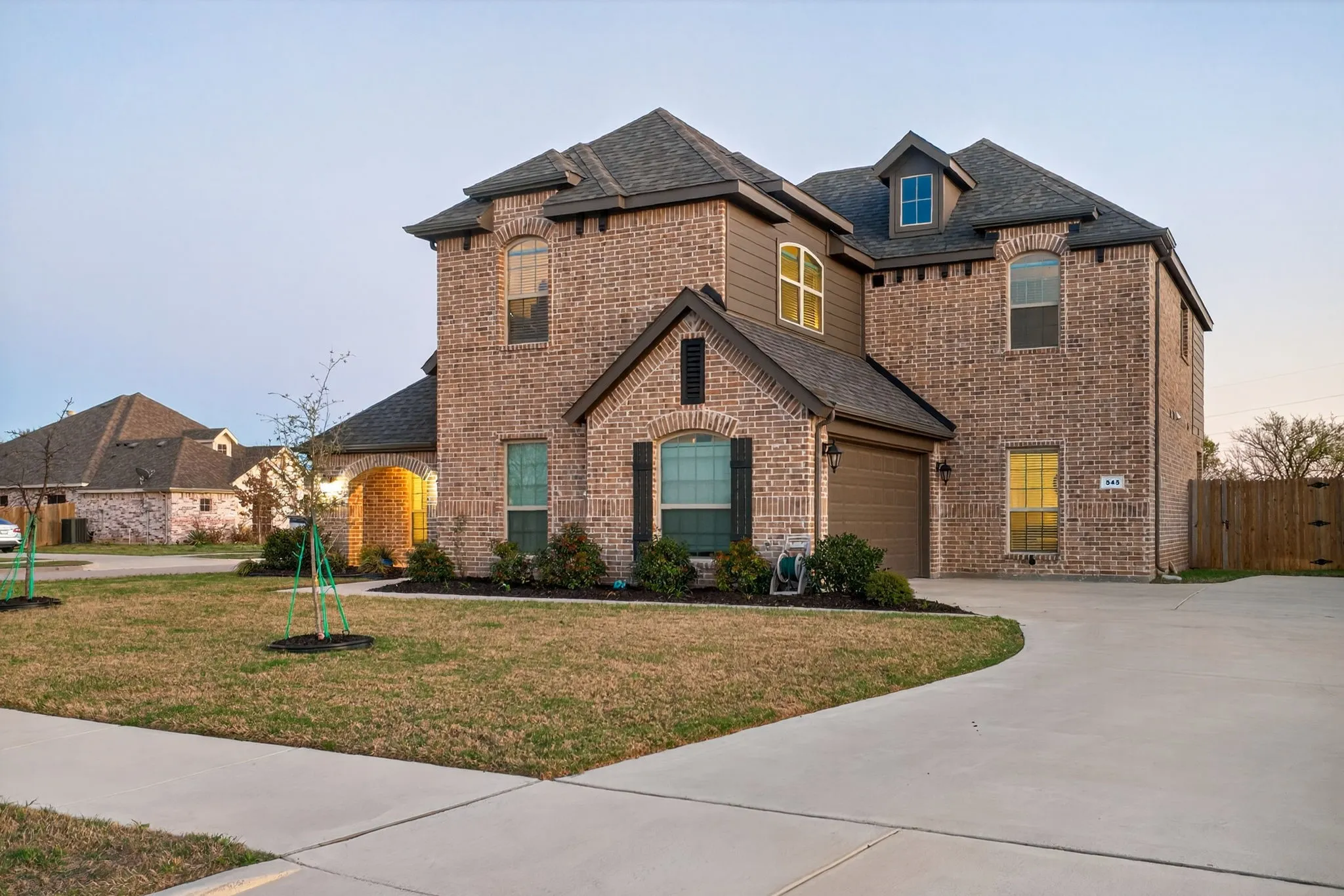 2022 build with side-facing garage, generous driveway and well-tended landscaping.