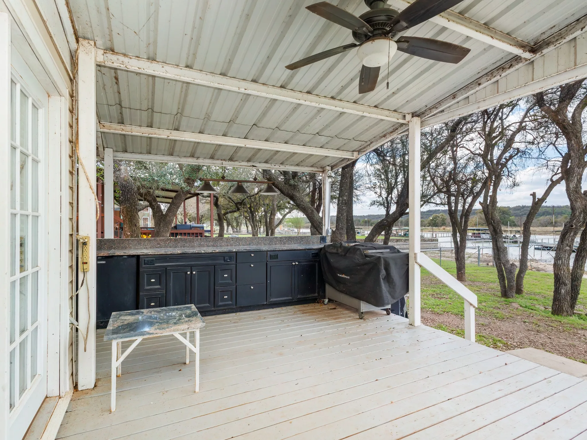 Wooden terrace with ceiling fan and an outdoor kitchen