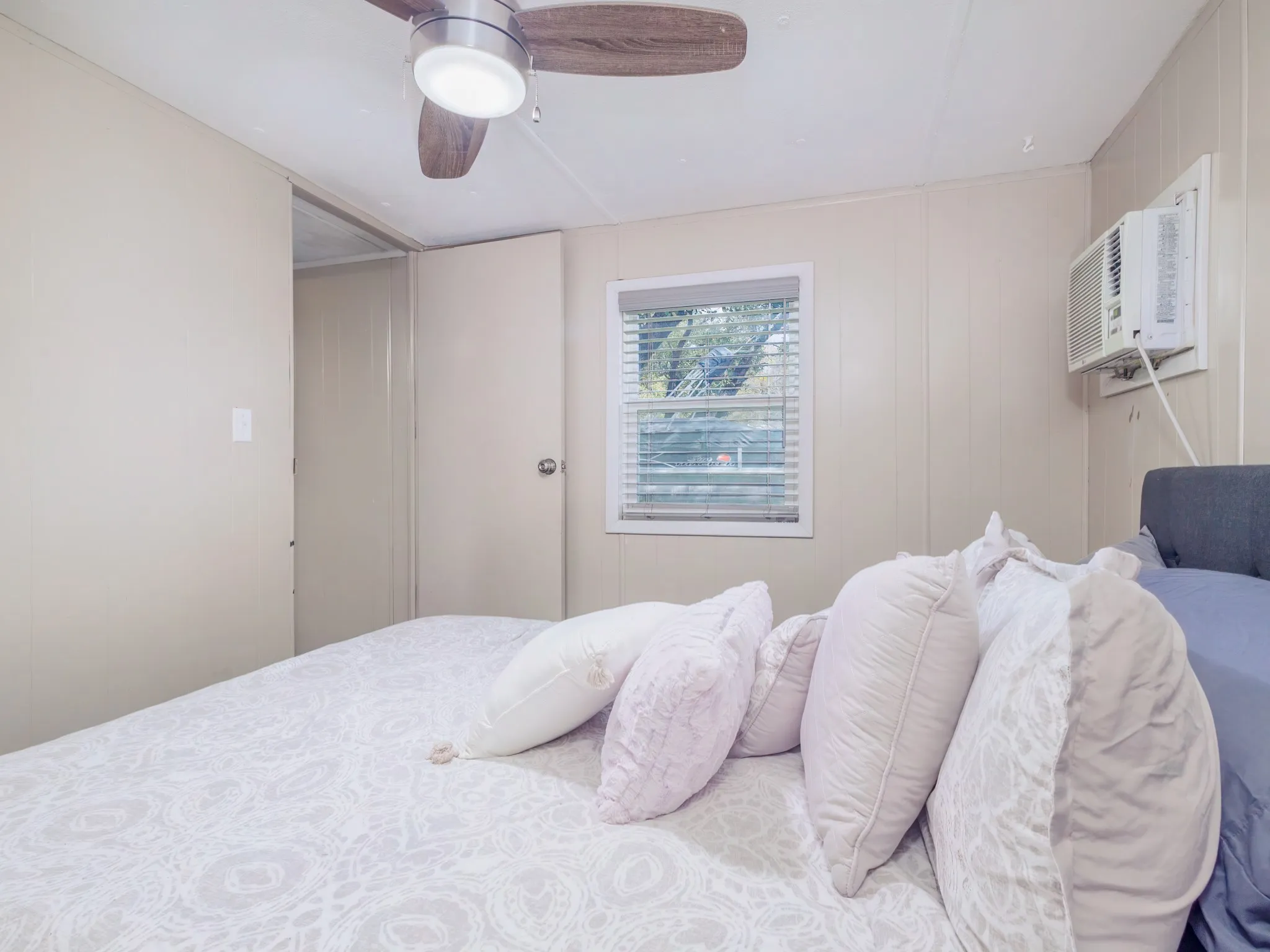 Bedroom with a ceiling fan and an AC wall unit