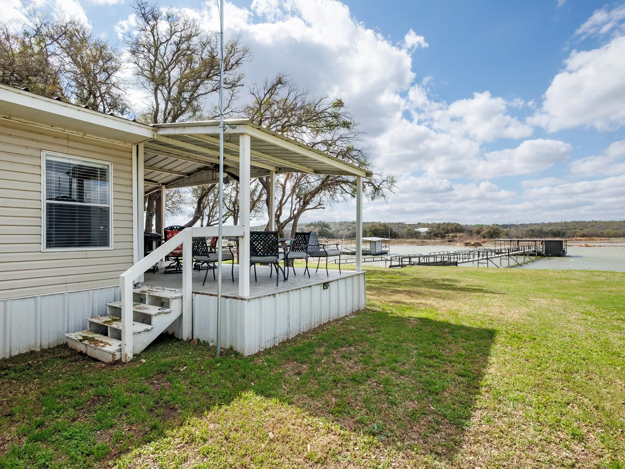 View of grassy yard with a wooden deck