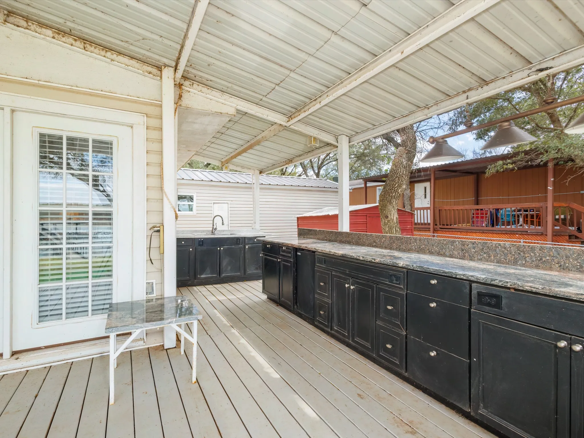 Deck featuring exterior kitchen and a sink
