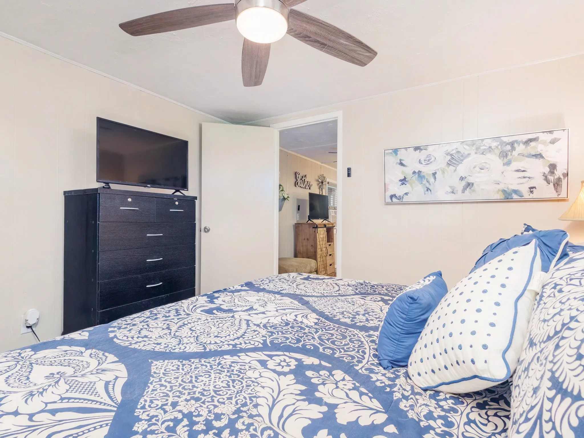 Bedroom with ceiling fan and wooden walls