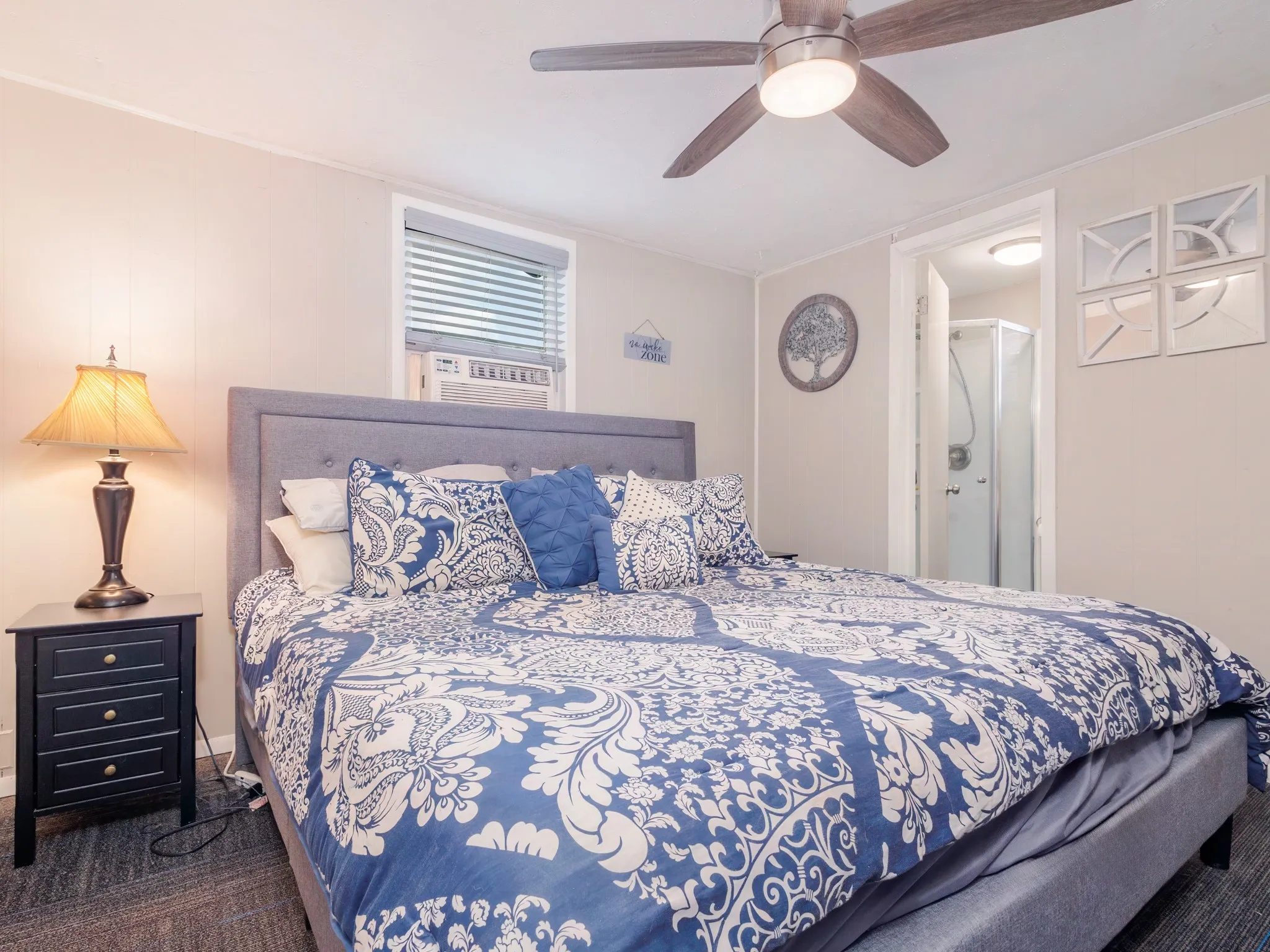 Bedroom with a ceiling fan, cooling unit, and connected bathroom