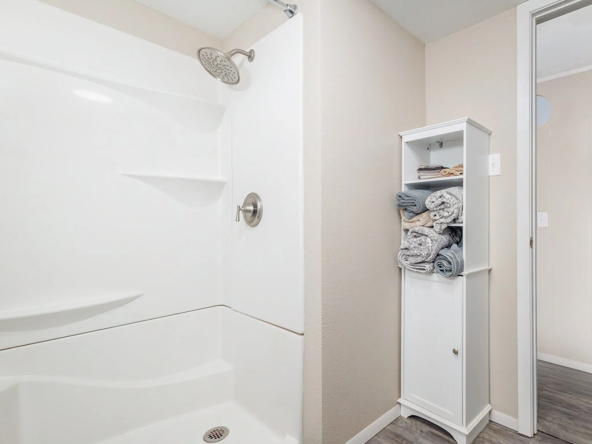 Bathroom featuring a stall shower, wood finished floors, and ornamental molding