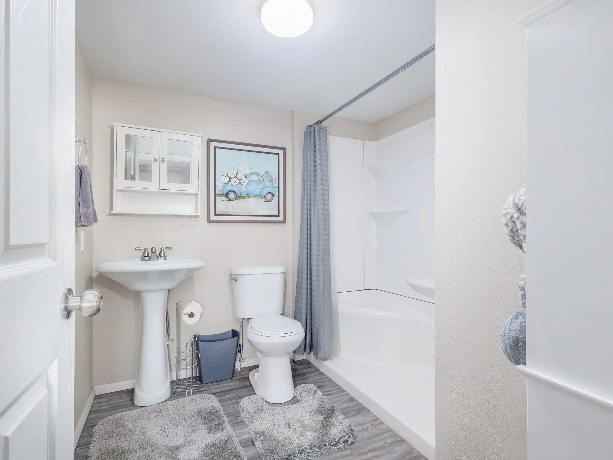 Bathroom featuring curtained shower and wood finished floors
