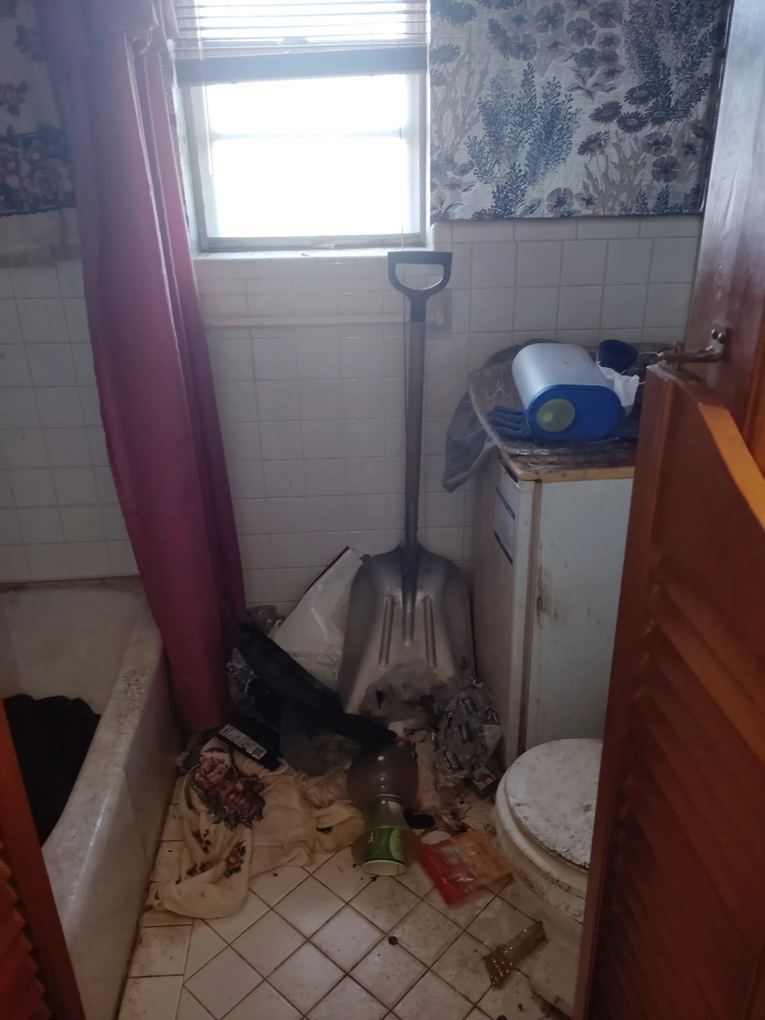 Bathroom featuring tile walls, light tile patterned flooring, wallpapered walls, shower / bath combination with curtain, and a wainscoted wall