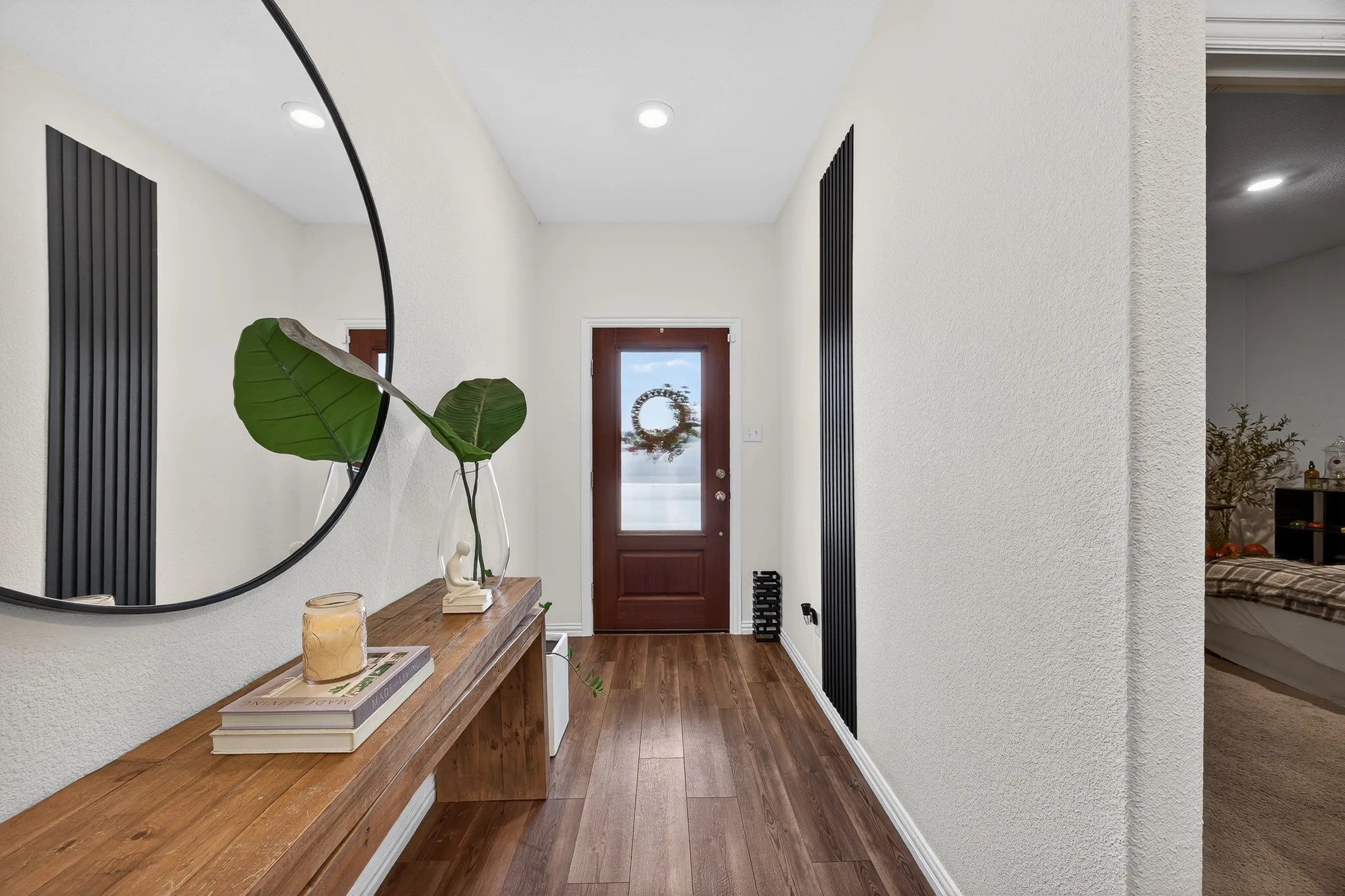 Doorway with hardwood / wood-style floors, a textured wall, and recessed lighting