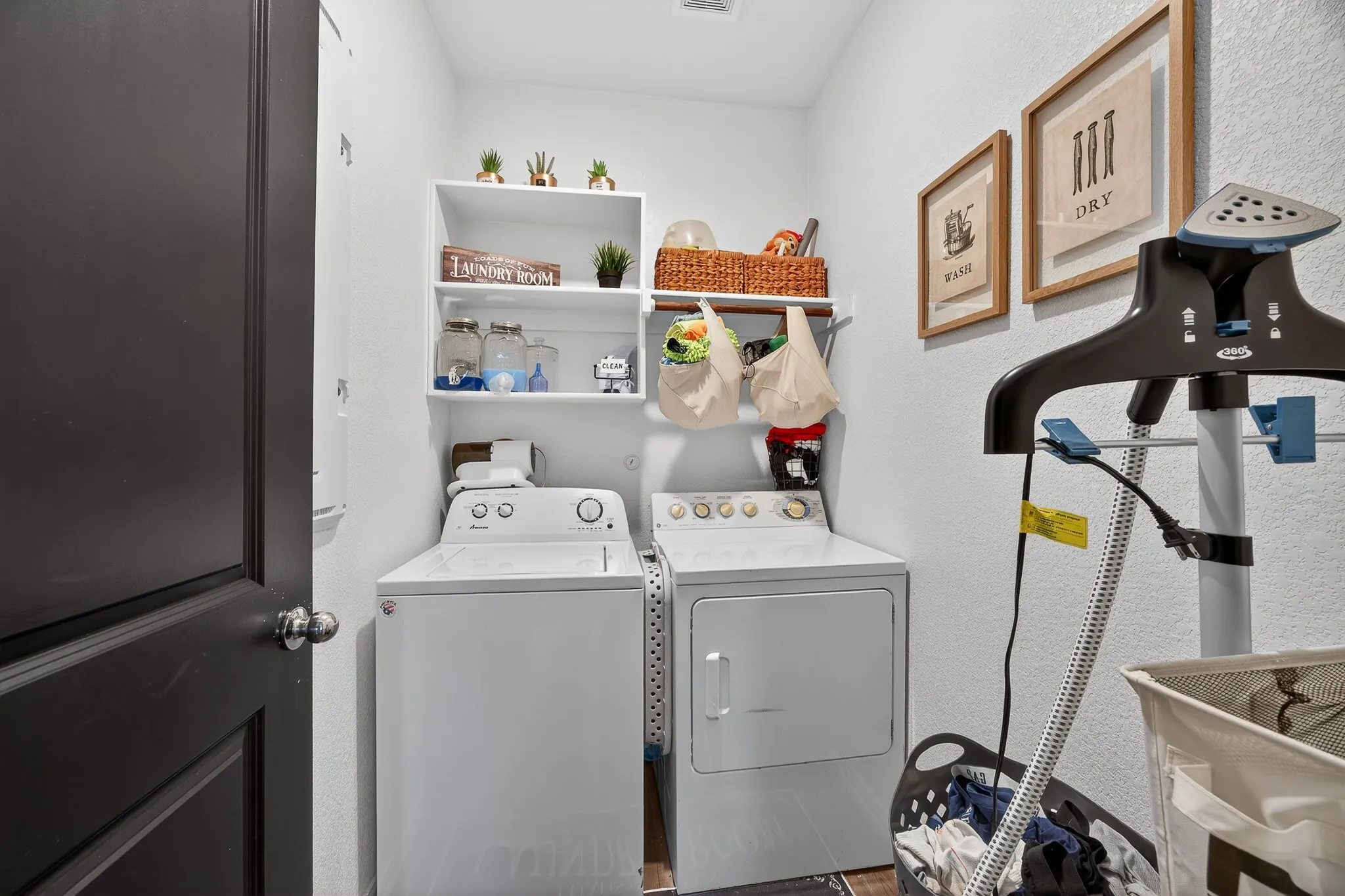 Laundry area featuring separate washer and dryer and a textured wall