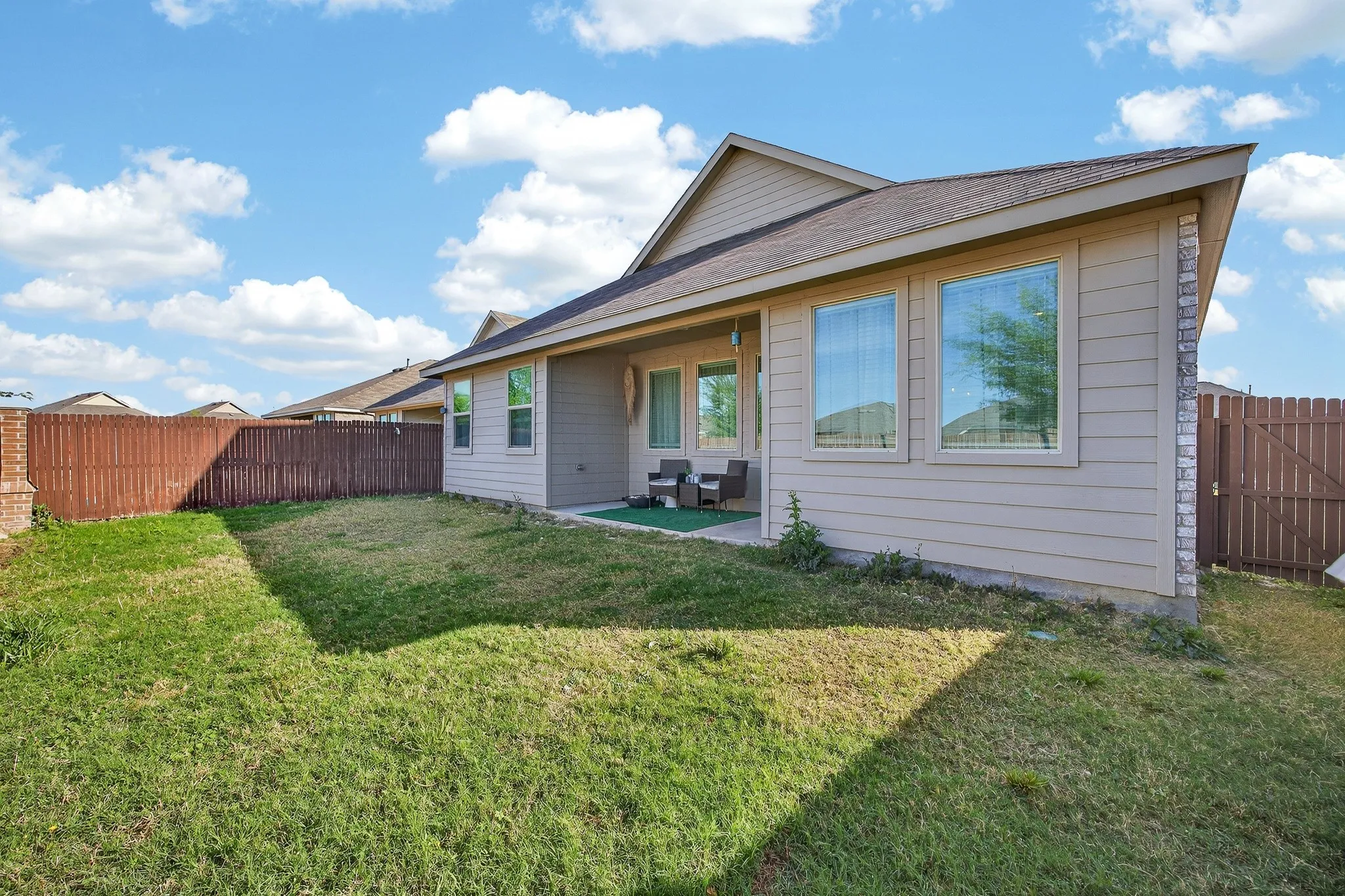 Rear view of house with a patio area, a fenced backyard, and a shingled roof