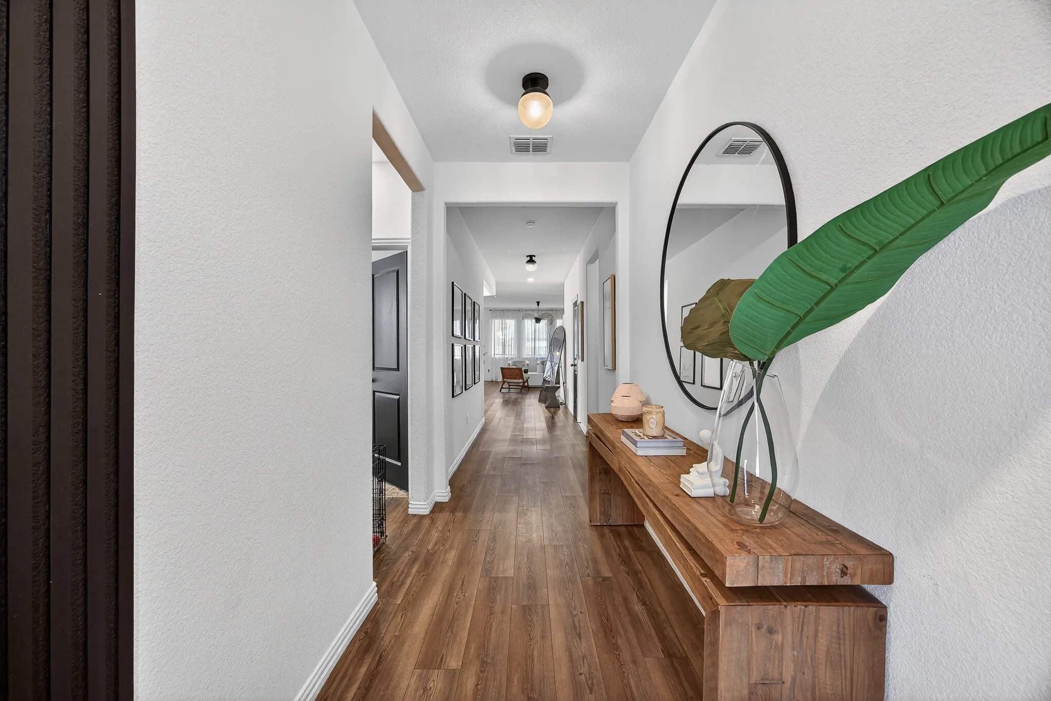 Corridor featuring dark wood-style flooring and a textured wall
