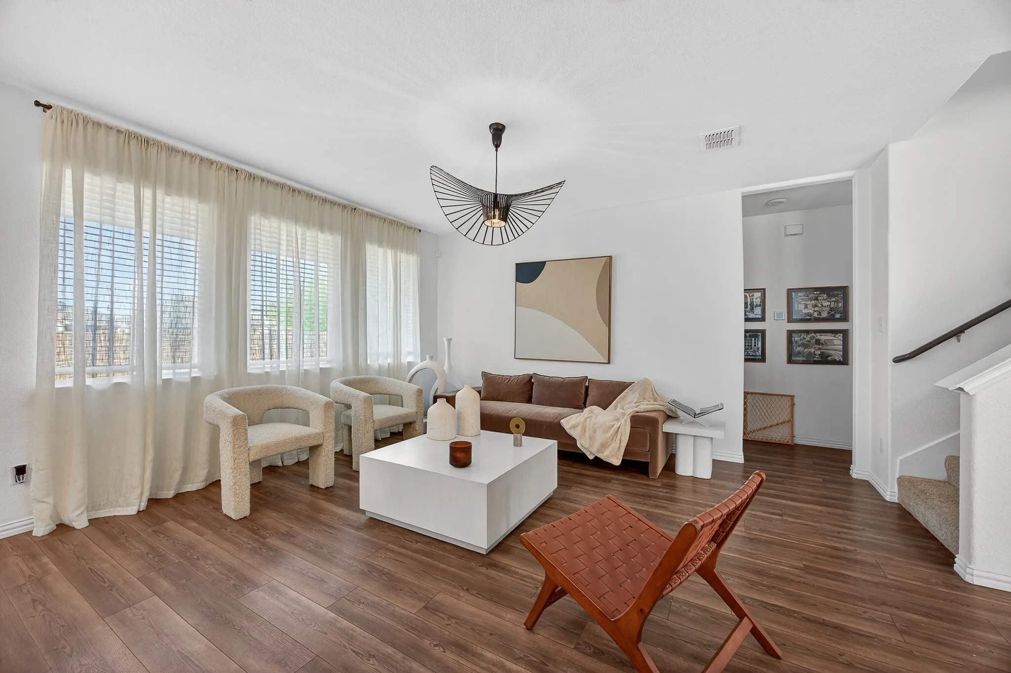 Living room with dark wood-style floors and stairway