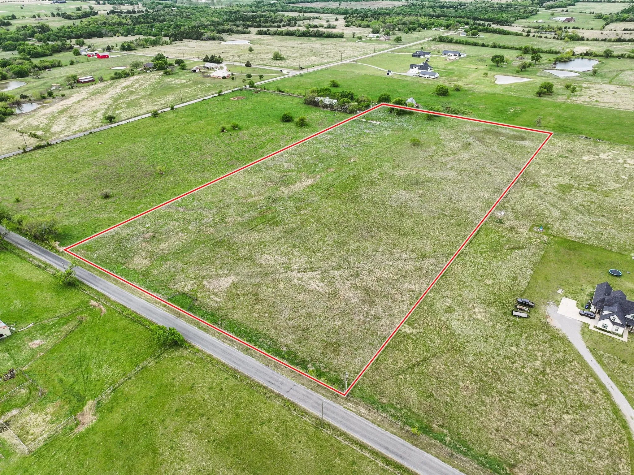 Expansive open land parcel featuring a perimeter marked by a red boundary line