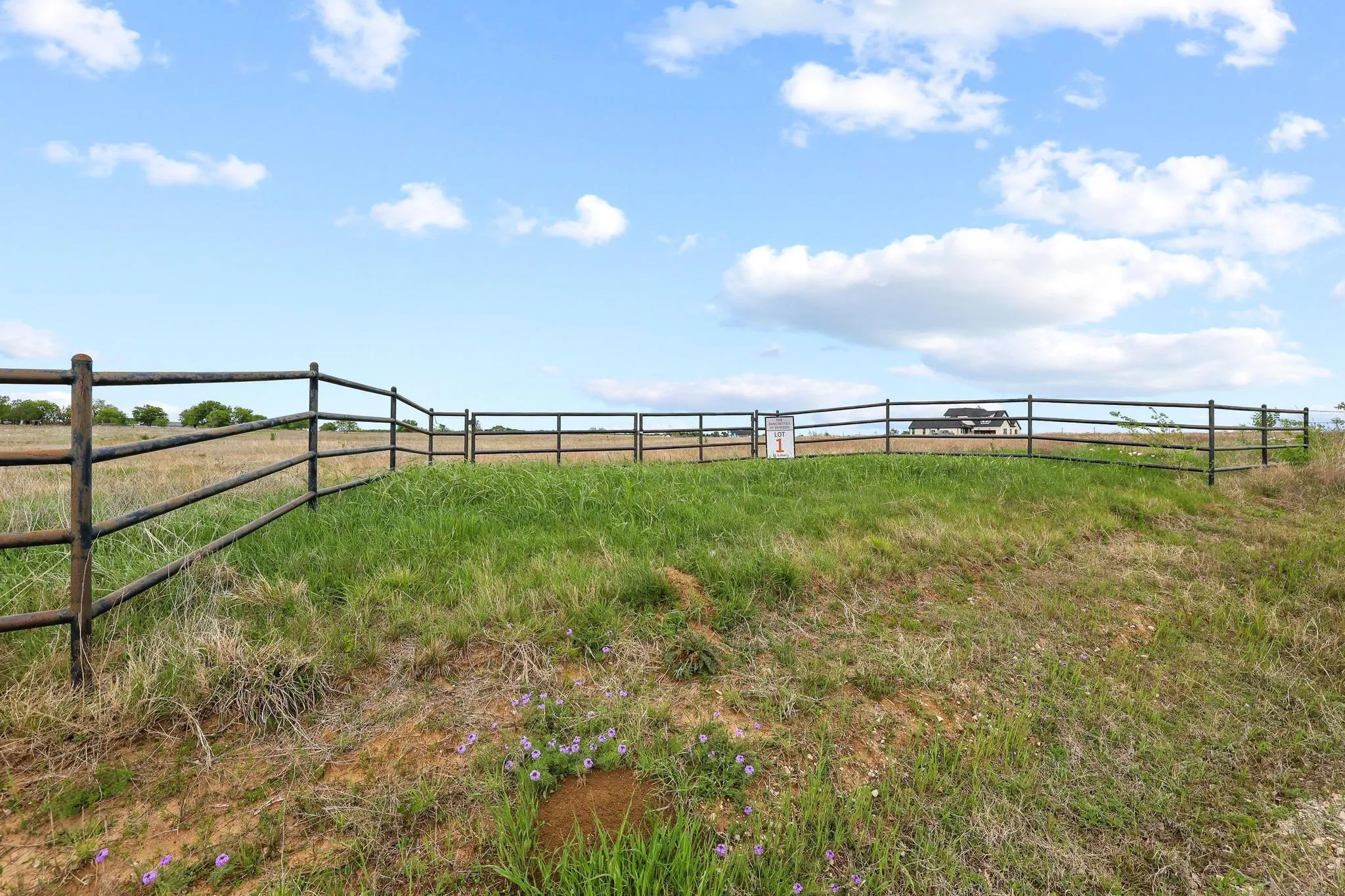 Fenced property featuring a gently sloping grassy terrain