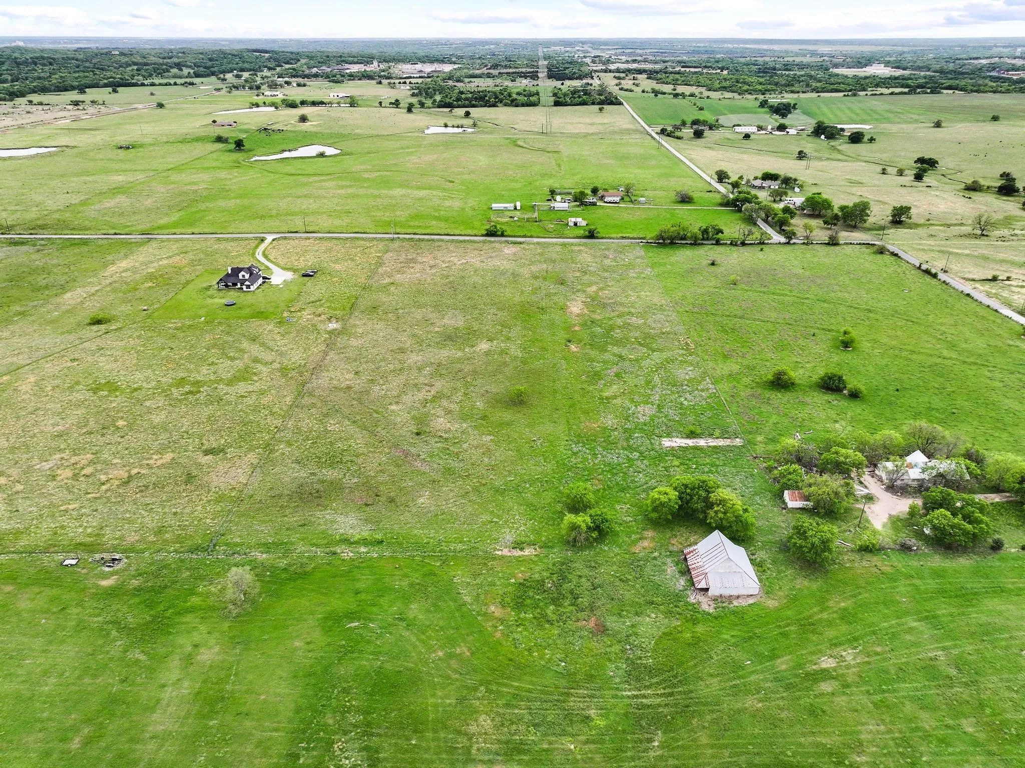 Expansive green landscape featuring varied terrain and multiple structures