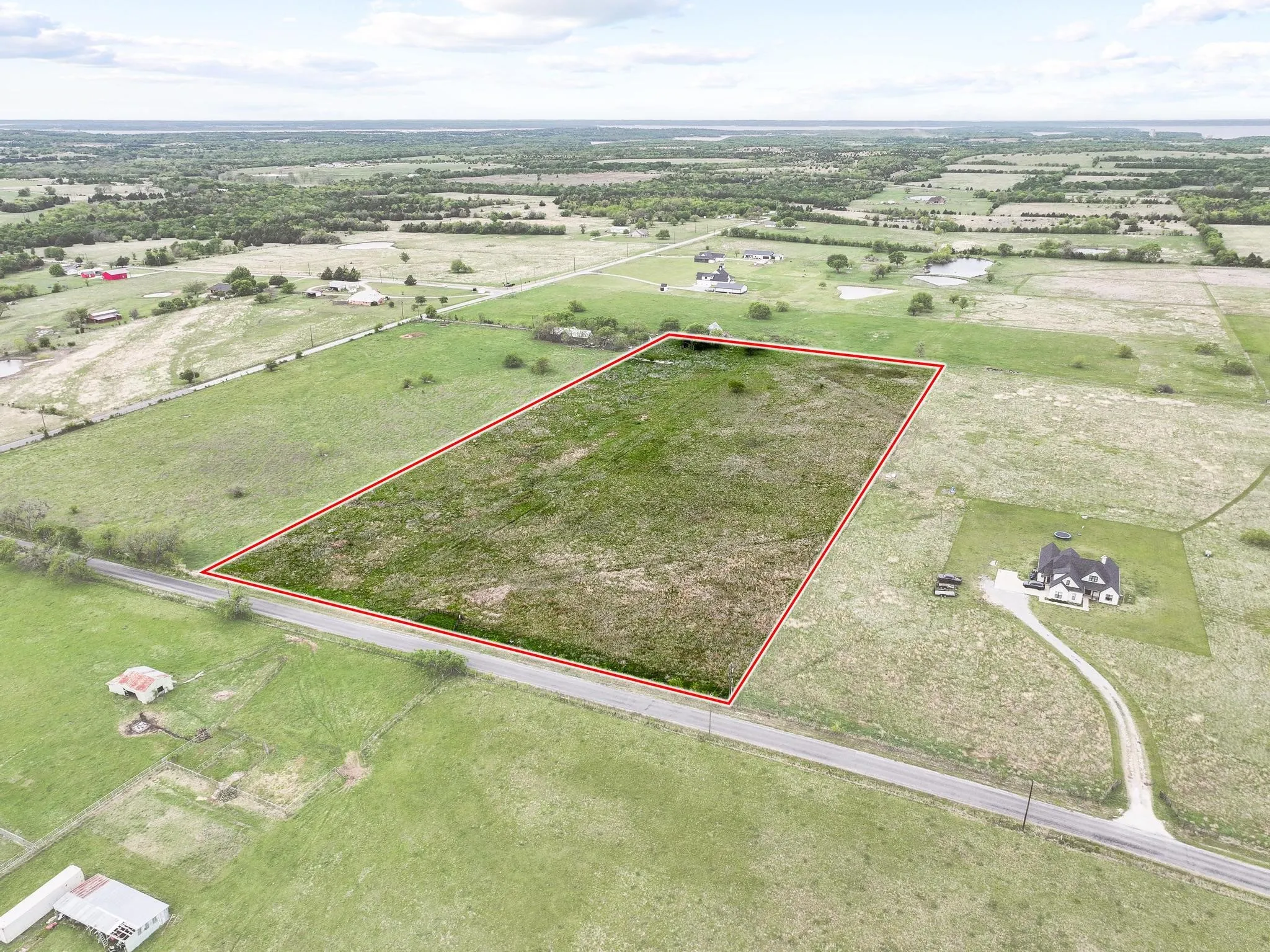 Expansive land parcel featuring a green, open field