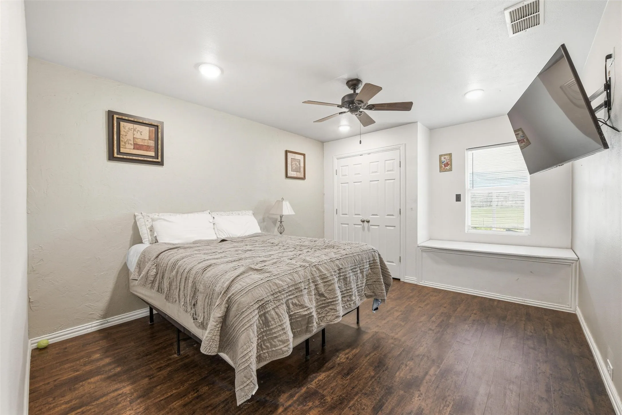 Bedroom with dark wood finished floors, a ceiling fan, and a closet