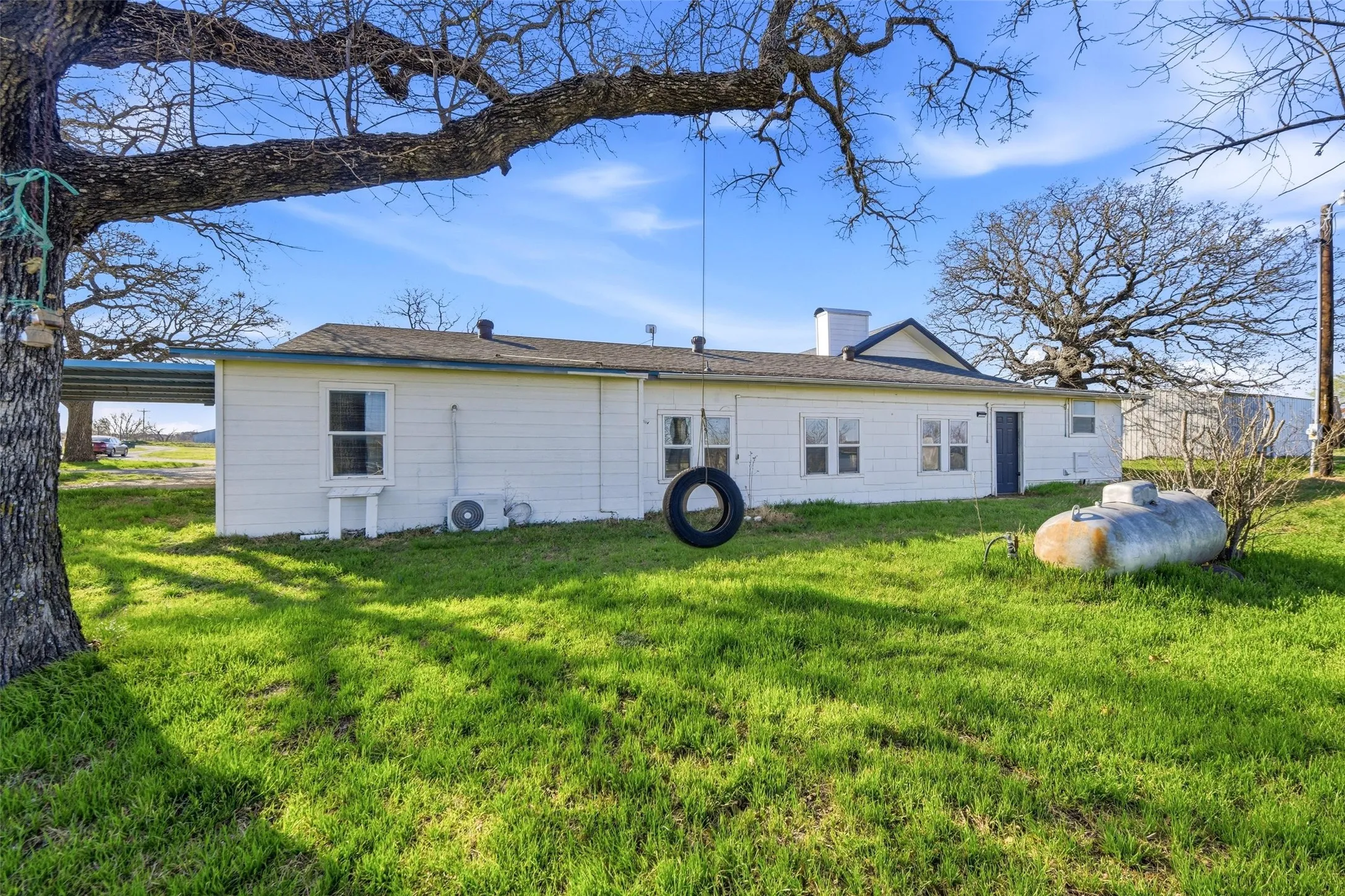 Back of property featuring a chimney and a lawn