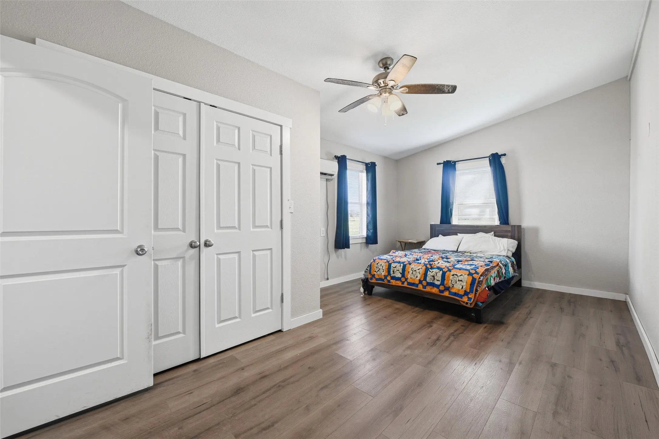 Bedroom with dark wood-style floors, a ceiling fan, and a closet