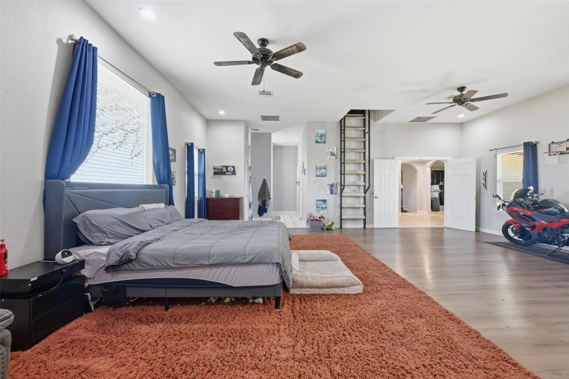 Bedroom with wood finished floors, recessed lighting, and arched walkways
