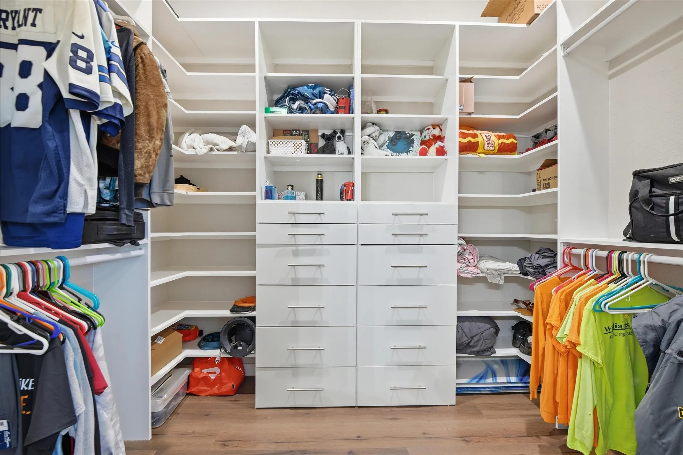 Walk in closet with light wood-type flooring