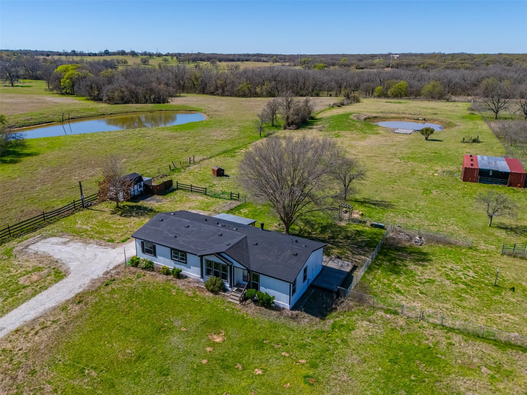 Aerial view of 13 acre property with home and pond in Whitney Texas
