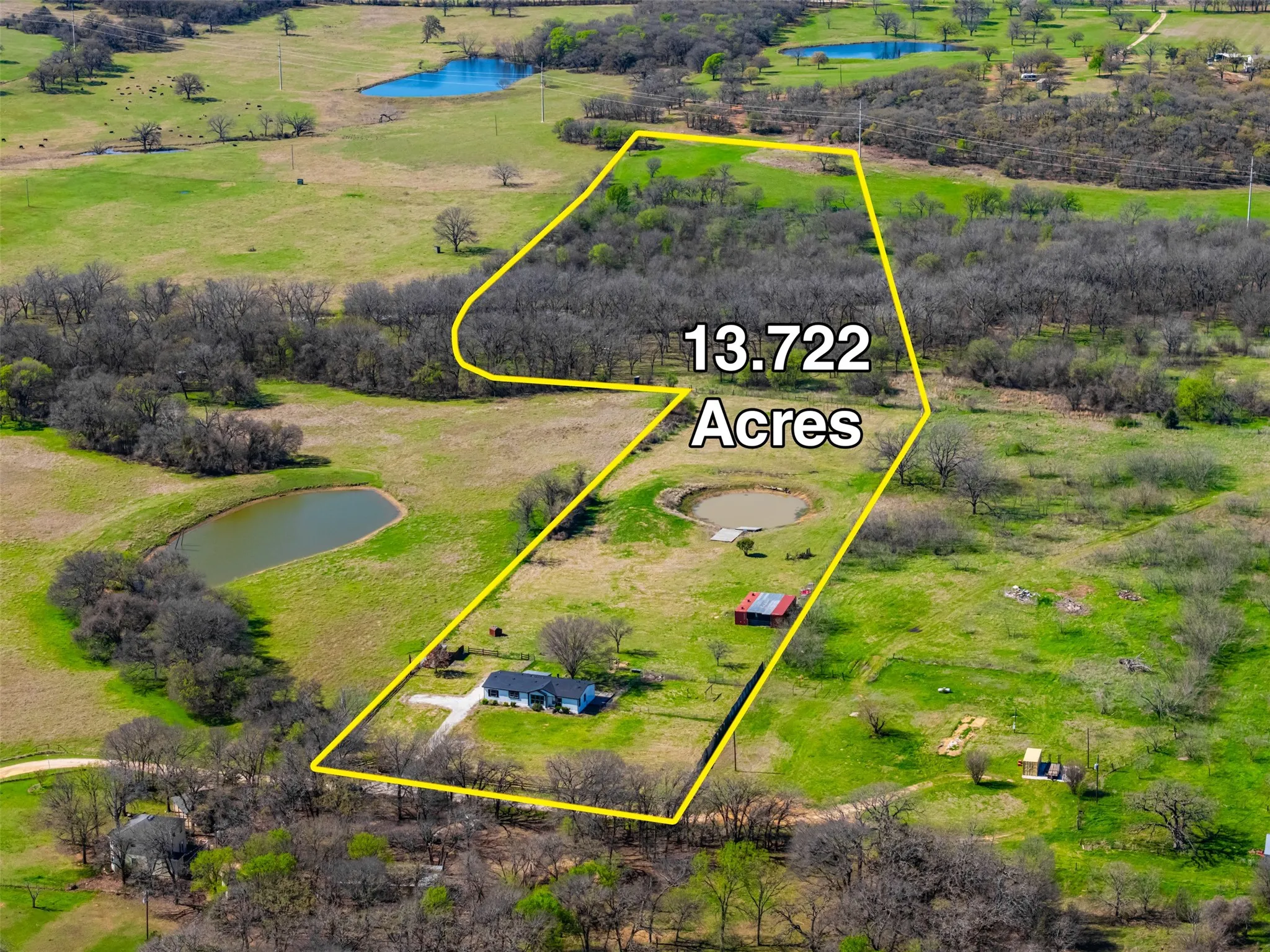 Overhead view of stocked pond, home, and outbuildings at 181 Private Road 125 Whitney TX