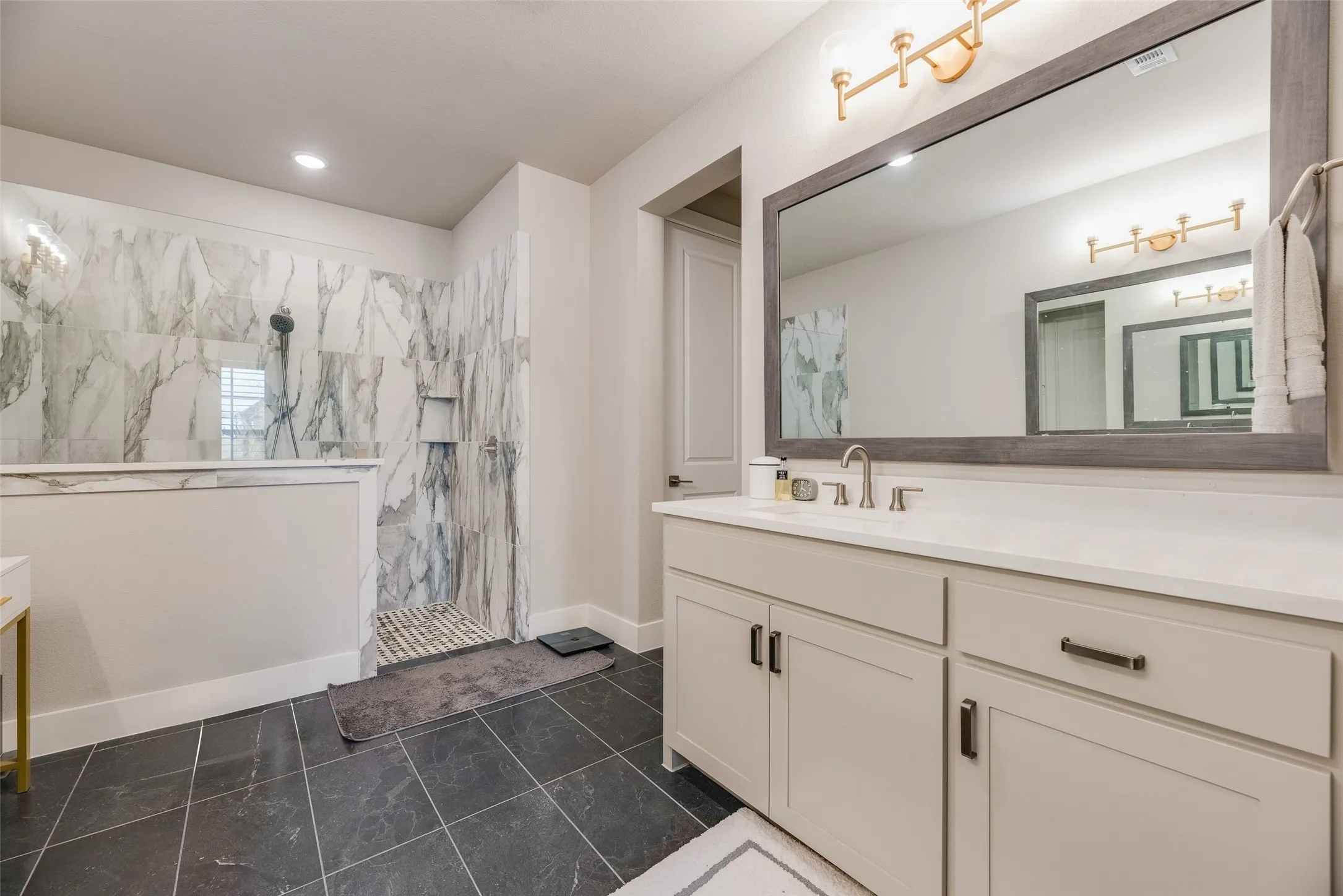 Walk-in shower with marble-look tile surround and built-in niche