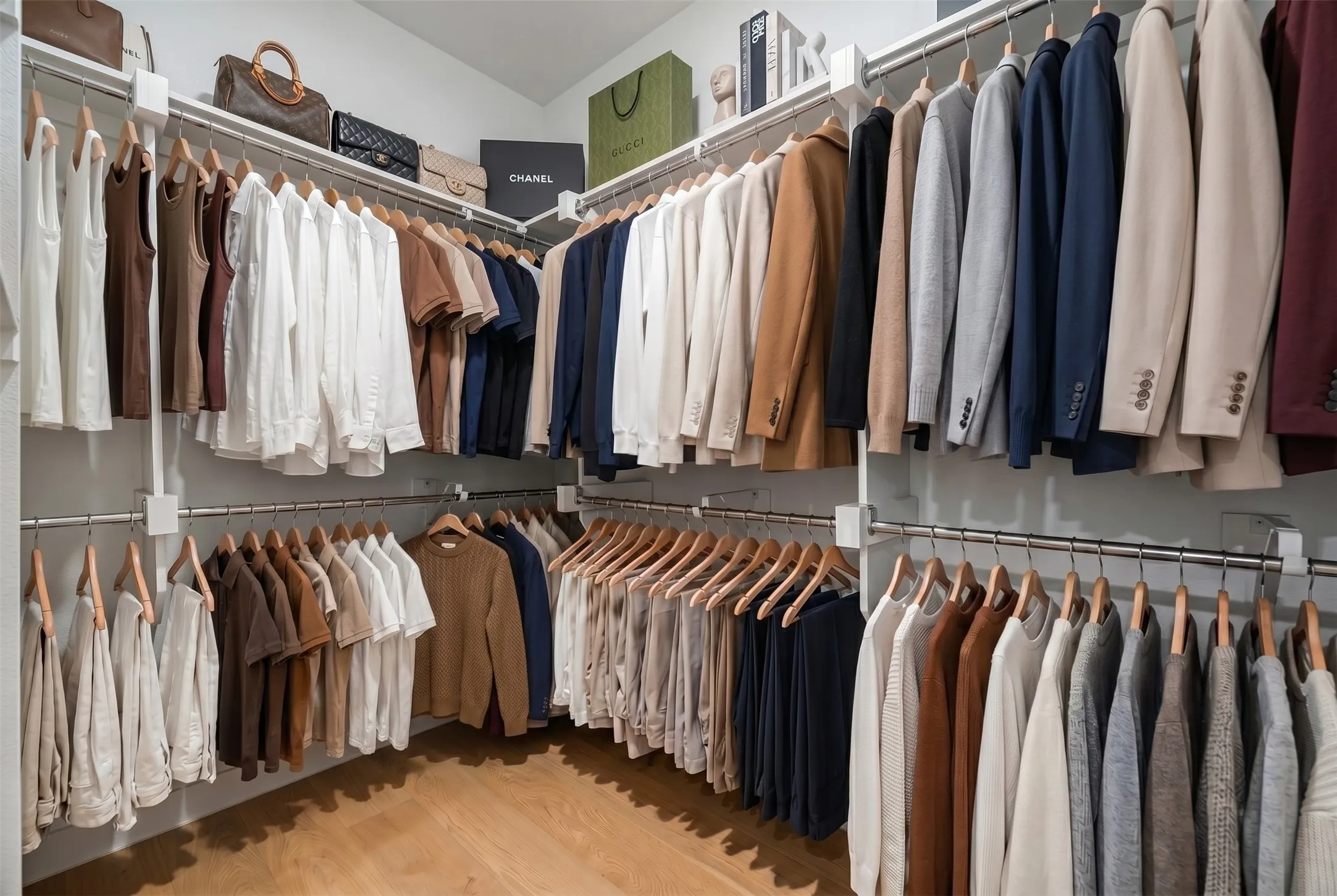 Custom-built closet system featuring multiple hanging rods, integrated shelving, and wood-finish flooring