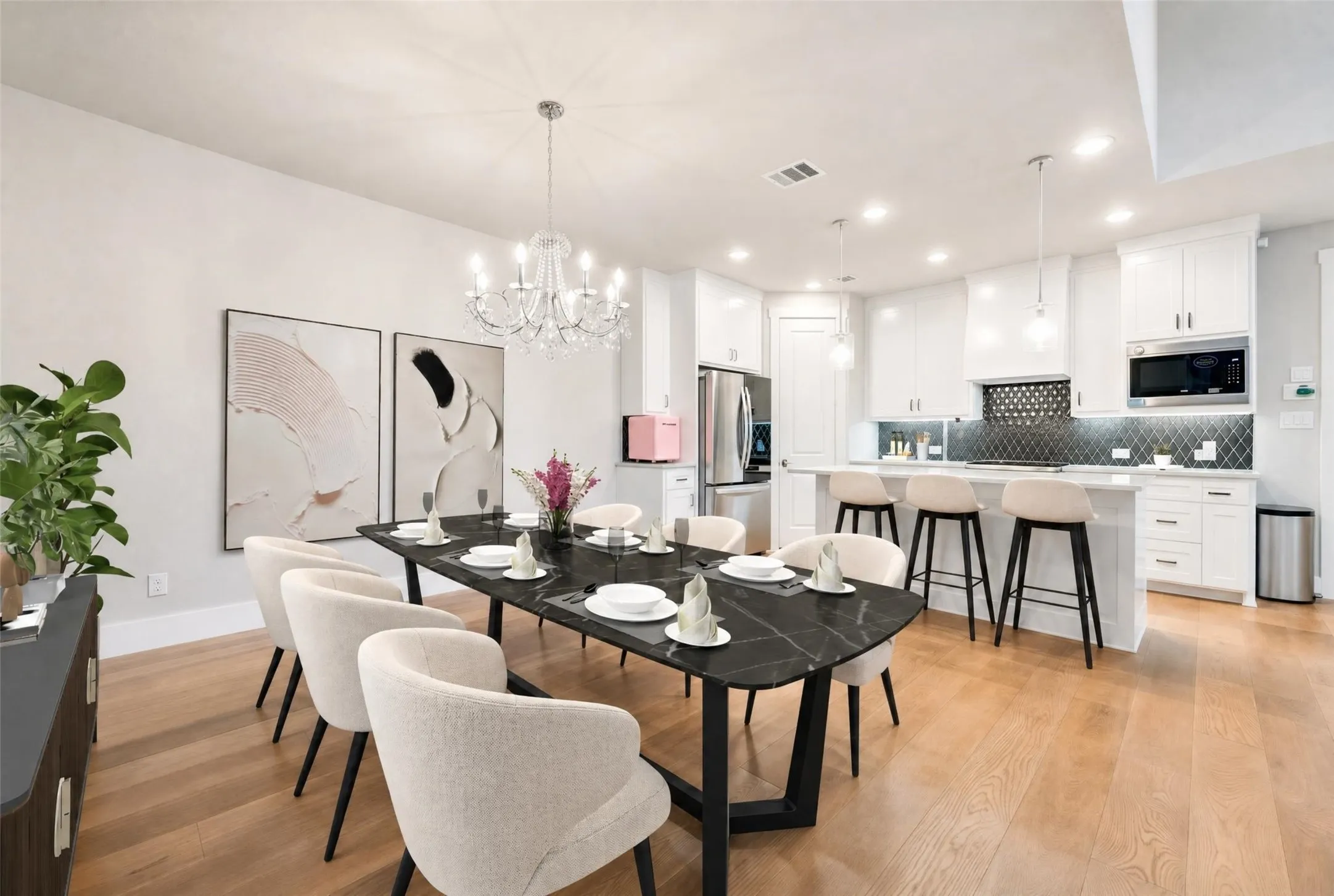 Open-concept dining and kitchen space featuring wood-finish flooring