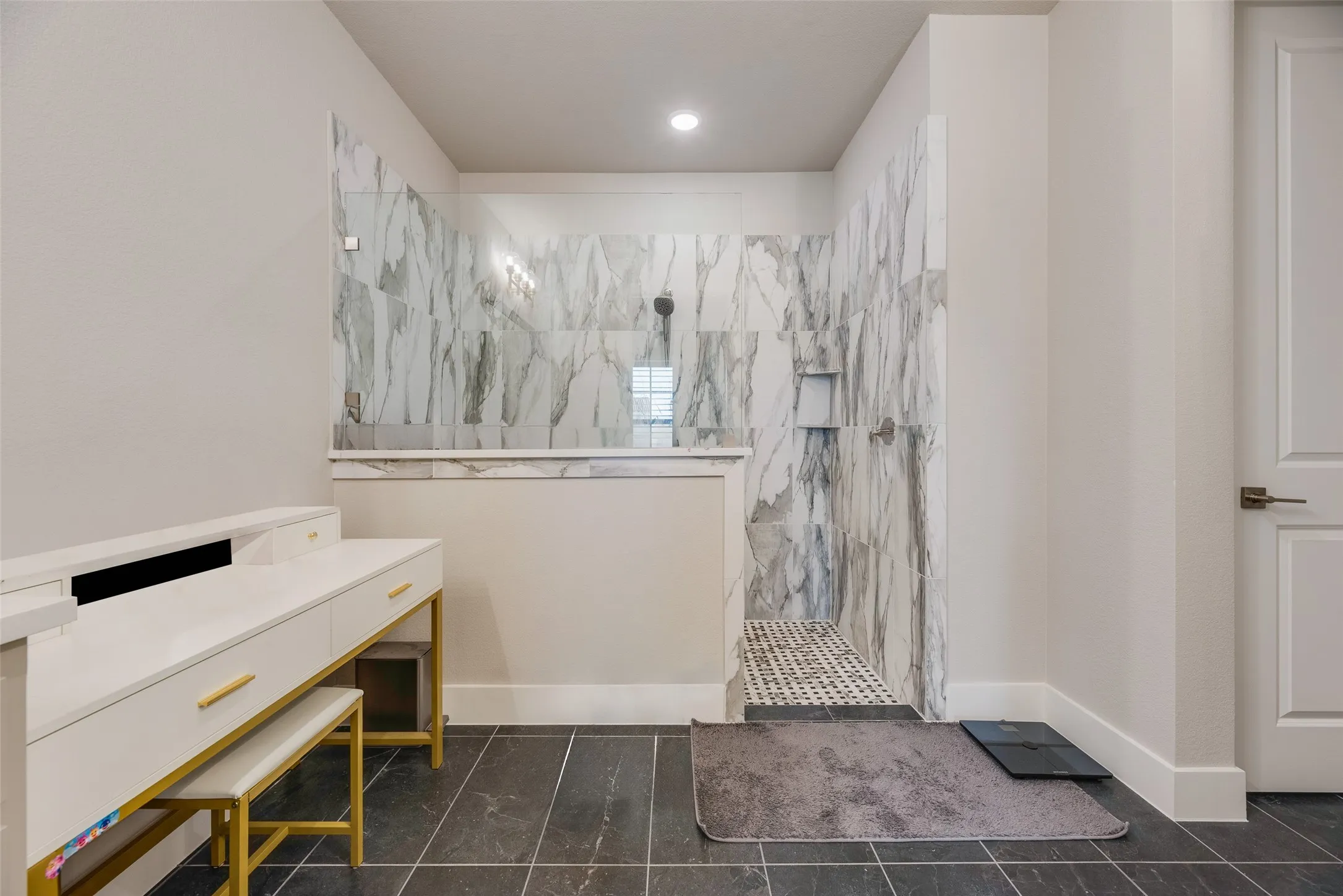 Spacious walk-in shower featuring large format marble-look tile, a built-in niche, and a contrasting mosaic tile​​‌​​​​‌​​‌‌​‌‌​​​‌‌​‌​‌​‌​​​‌​​ floor
