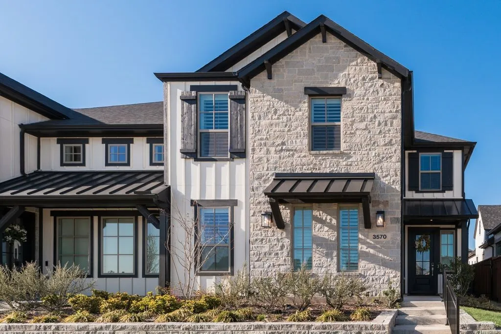 View of front facade with a standing seam roof, stone siding, and board and batten siding