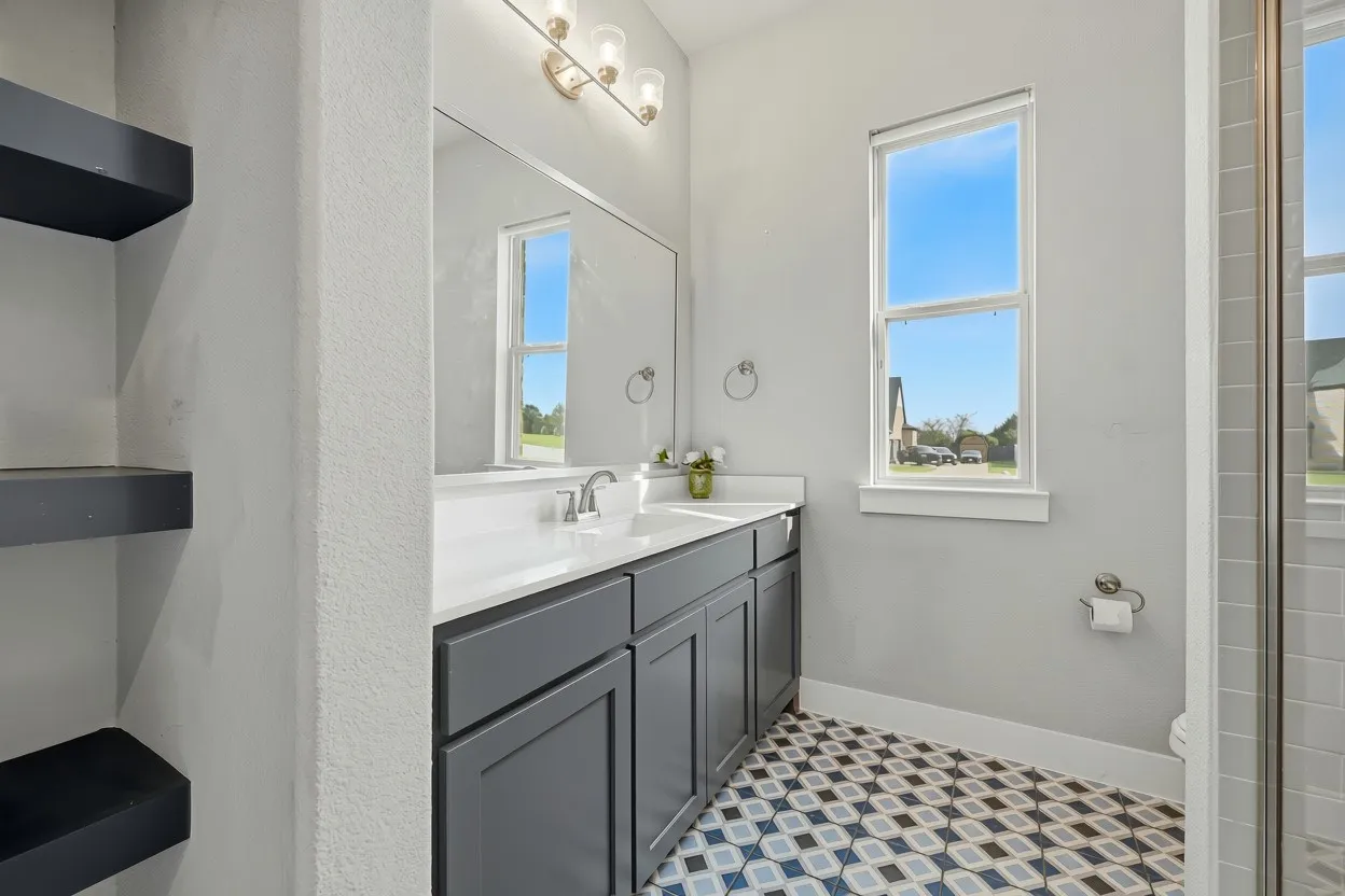 Bathroom featuring a dual vanity with a white countertop and dark cabinetry