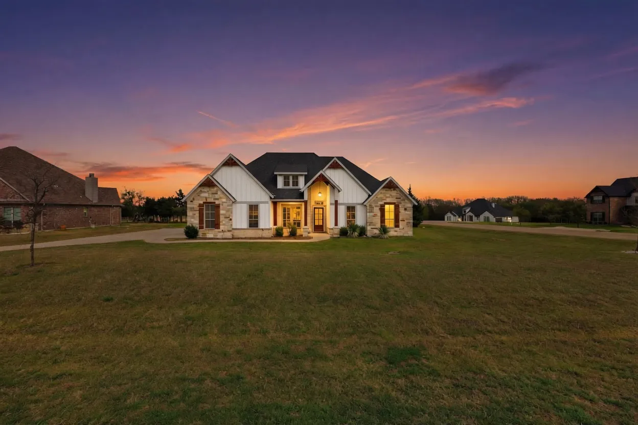 Expansive front lawn with a single-story residence featuring a mixed facade of stone and white siding