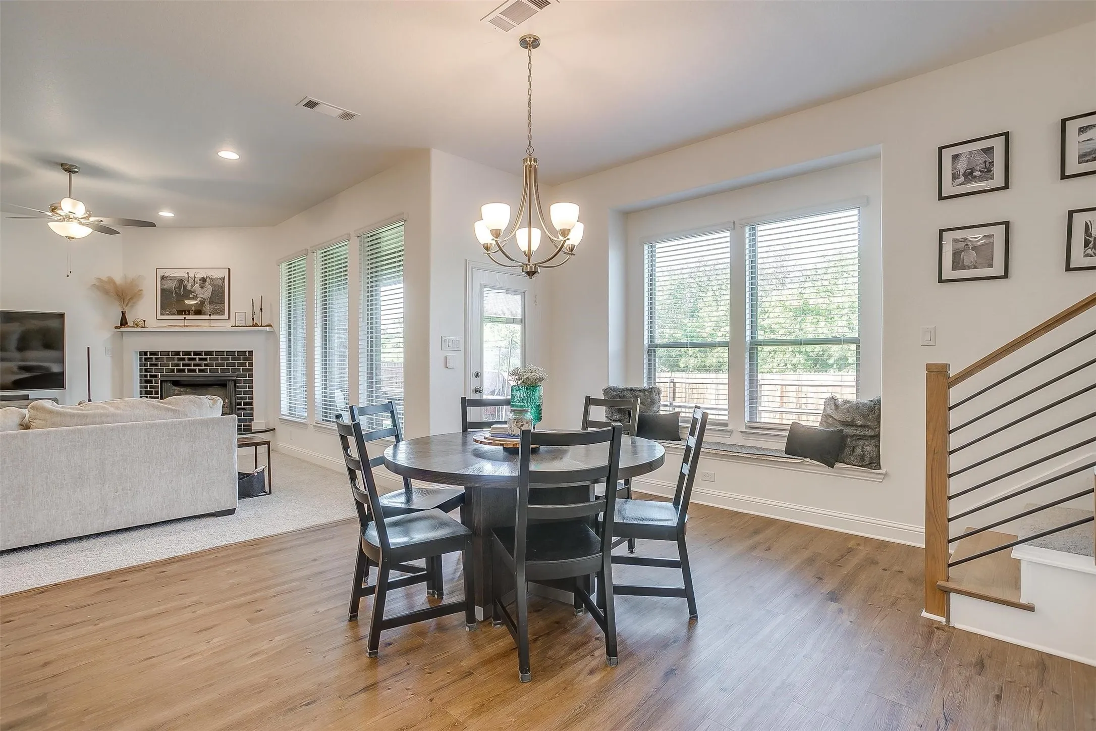 The dining area, which has plenty of space to accommodate your dining table, also has a built-in bench for extra seating if you have a farm table.  Solid flooring is easy-care and works well in this dining area that has beautiful outdoor views of the back yard and beyond to the tree-lined space behind.