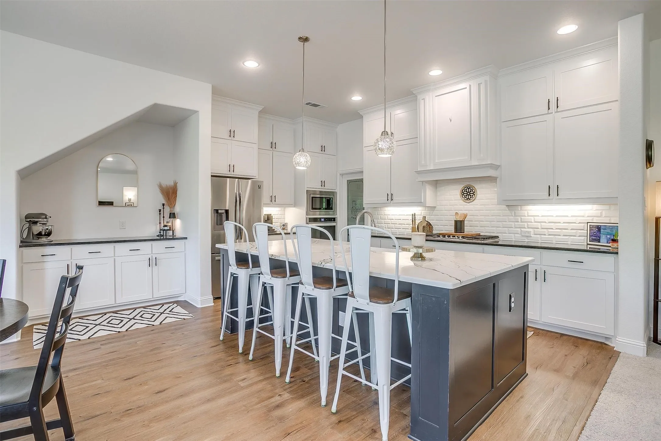 Adjacent to the kitchen area is an additional bar cabinet space for your coffee maker or other appliances along with countertop space for food prep and built-in cabinets below.