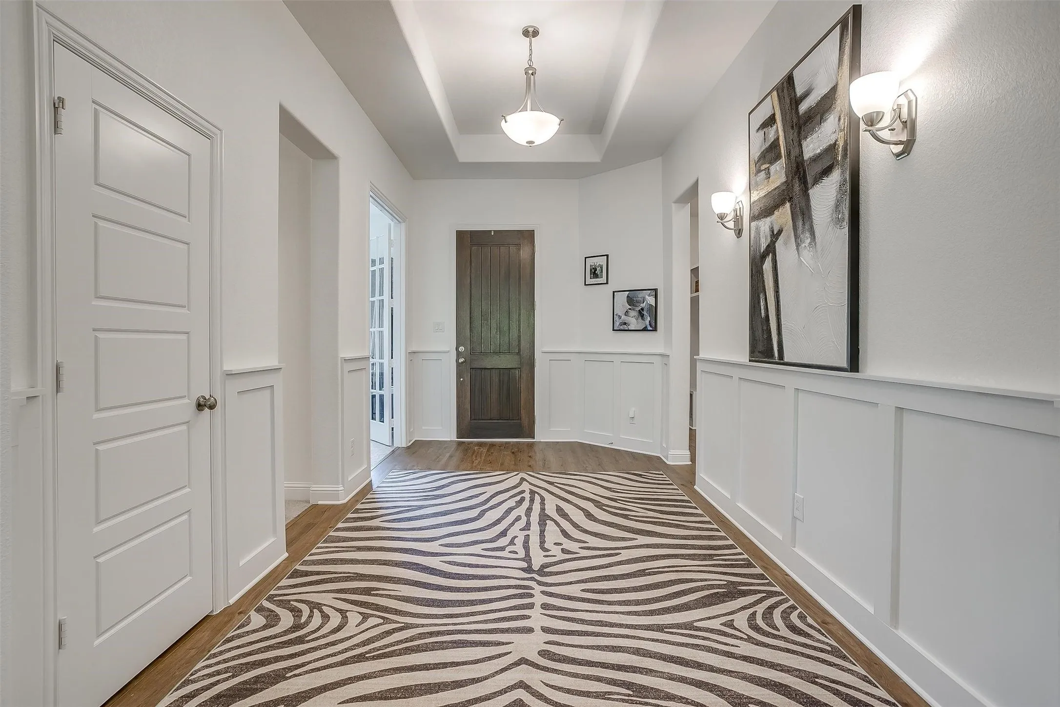 This elegant wainscoted entry is very wide and engaging -- perfect for your decorative furnishings and art.  Recessed box ceiling is part of the architectural design to make this area more spacious.
