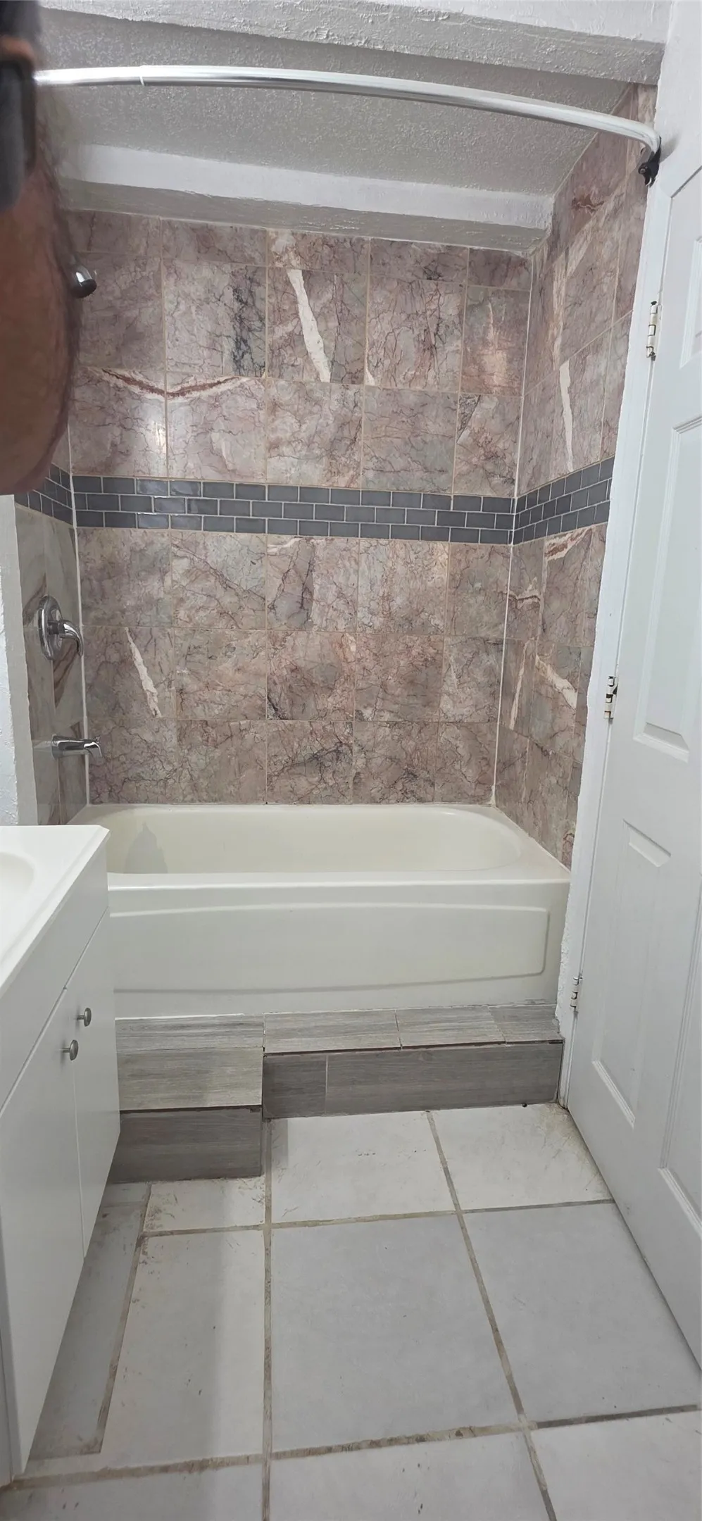 Bathroom featuring vanity, washtub / shower combination, and light tile patterned floors