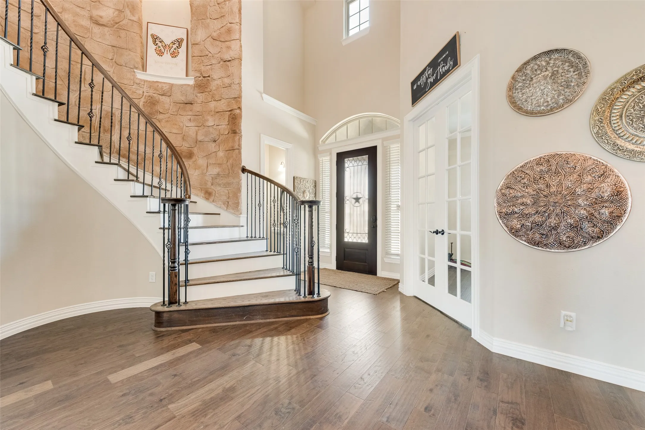 Grand entry with soaring ceiling, curved stair case, office with French door