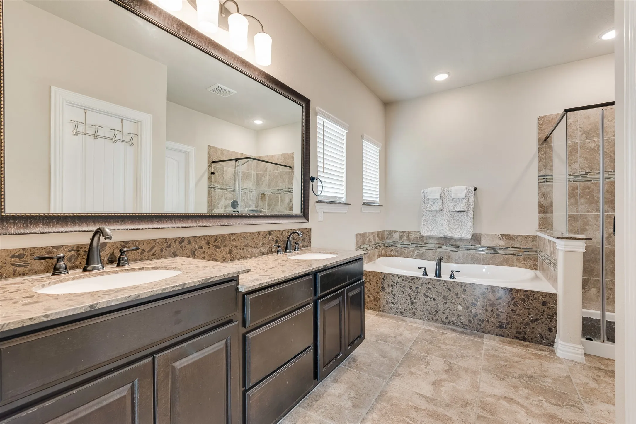 upstairs primary bathroom with garden tub, separate shower, dual sinks