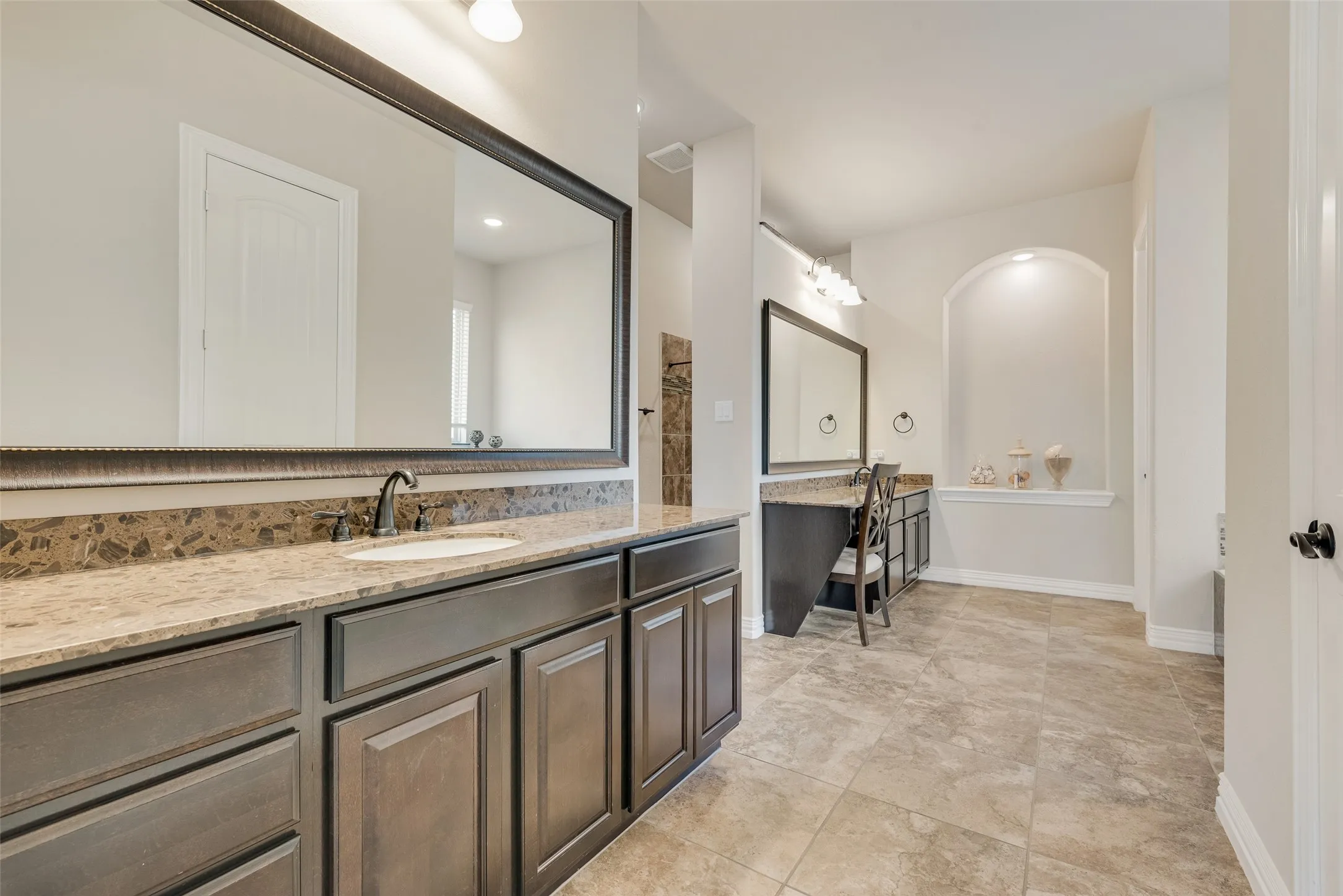 spacious primary bathroom with dual vanities