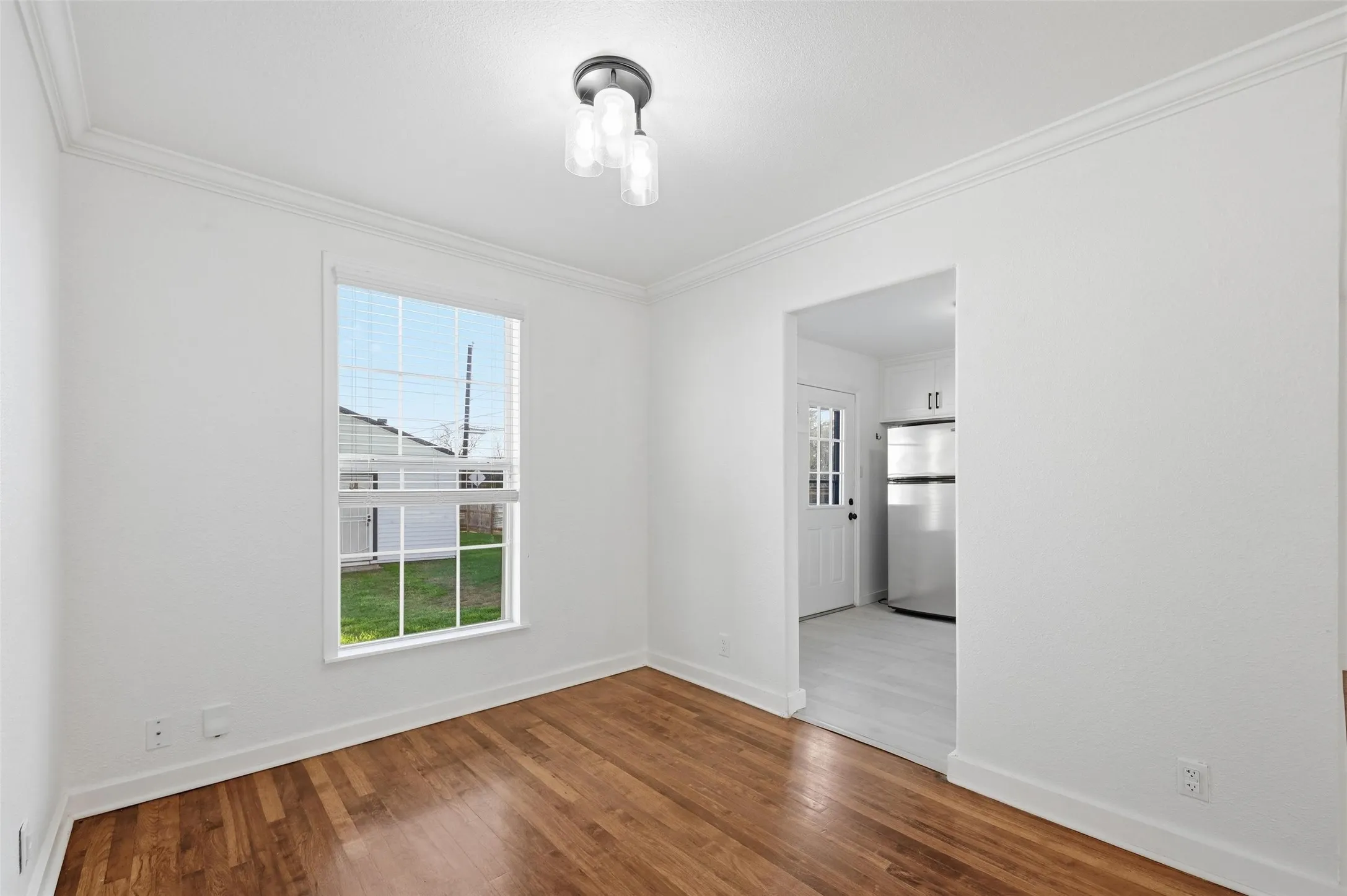 Empty room featuring wood finished floors and ornamental molding
